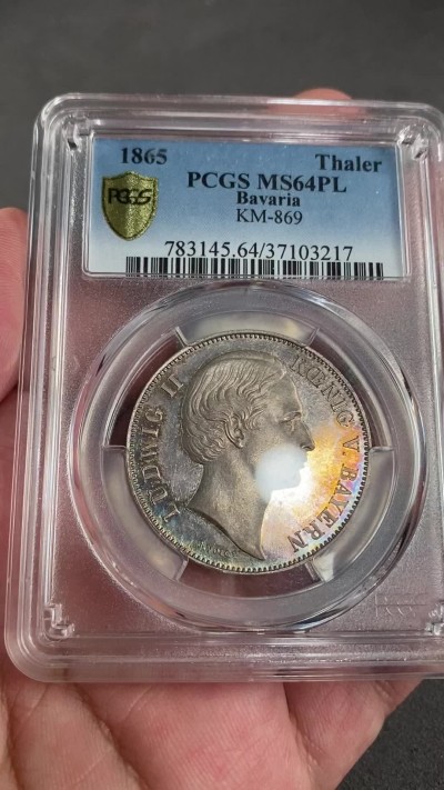 凡希万国世界钱币年度大拍第二季 PCGS MS64PL 1865年德国法巴利亚路德维希二世双狮流通1泰勒 唯一冠军分类镜面精致五彩 高点人像与盾徽的喷砂感与如镜子般的底板形成极致反差 近200年形成的五彩斑斓如星星般点缀在正反币面的浮雕与字体之间 此枚难度与稀少程度在联合泰勒中都占有重要的一席之地