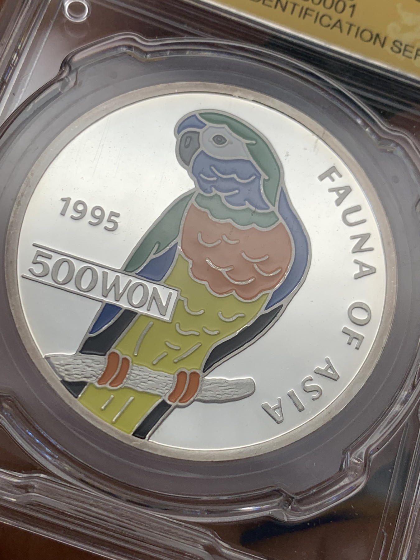 《竞宝斋》第232场-周日，周一 2场 (全场包邮) CSIS PF70UC 1995年朝鲜中央造币厂发型国徽版鹦鹉彩色精制银币，1OZ，31克，999银，完美品质，大热品种！