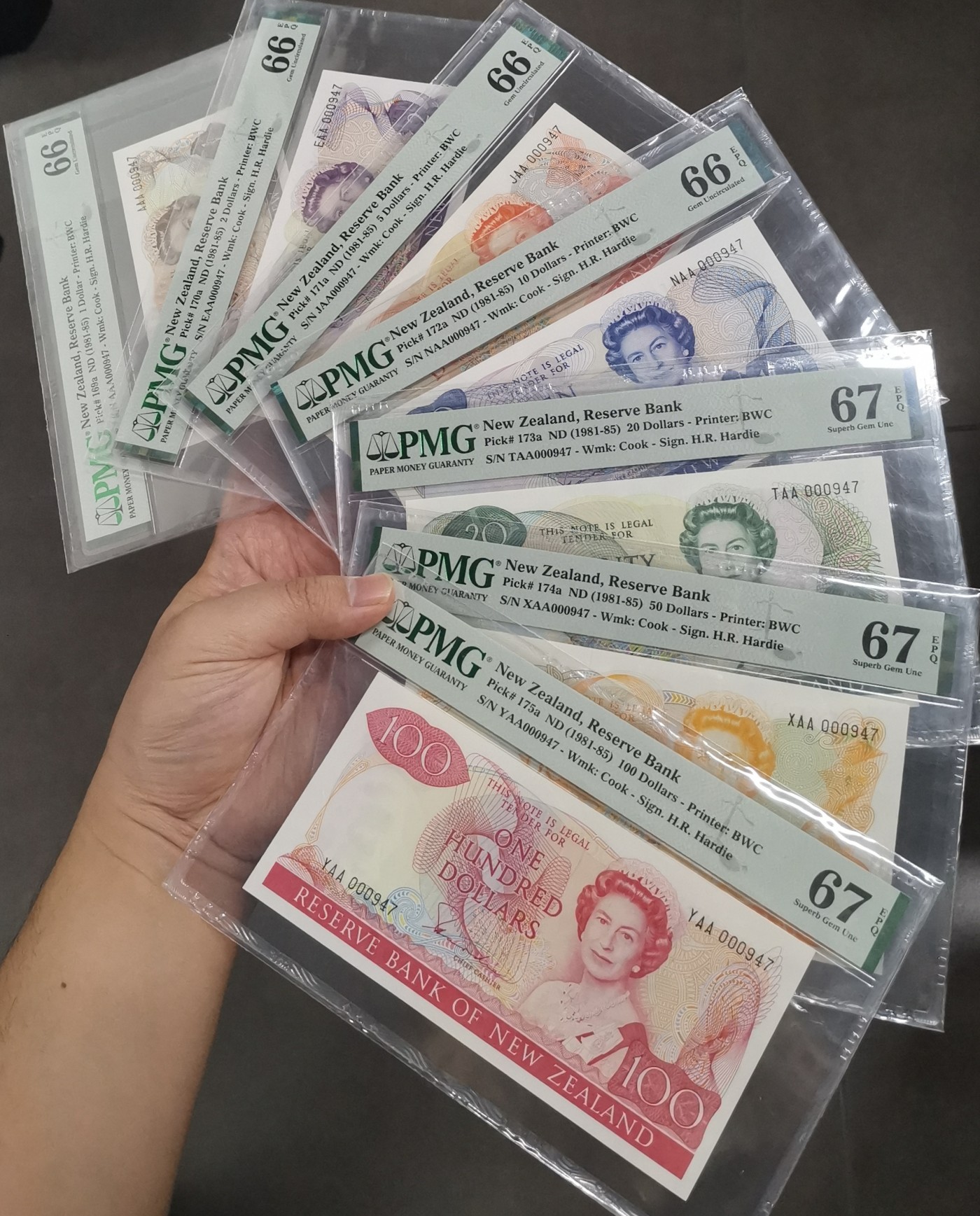 《张总收藏》135期-节前外币超精品场(欧亚名誉品) (7张全套全同号)新西兰1981年首发AA冠百位小号，花冠女王 100/50/20元PMG67E亚军分 10/5/2/1元PMG66E 分数非常整齐，全新壳欣赏舒服