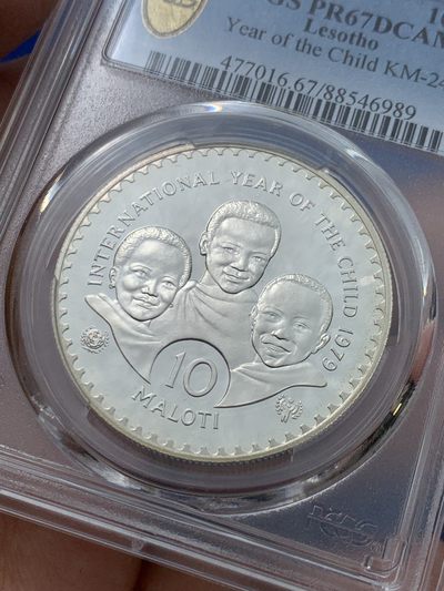 《竞宝斋》第239场-周日，周一 年终拍场 (全场包邮) PCGS-PR67 莱索托1979年国际儿童年10洛蒂精制纪念银币，直径40mm，重28.28g，925银，发行量37050枚。PROOF精制币，镜面状态，获得更高评级数量10枚。