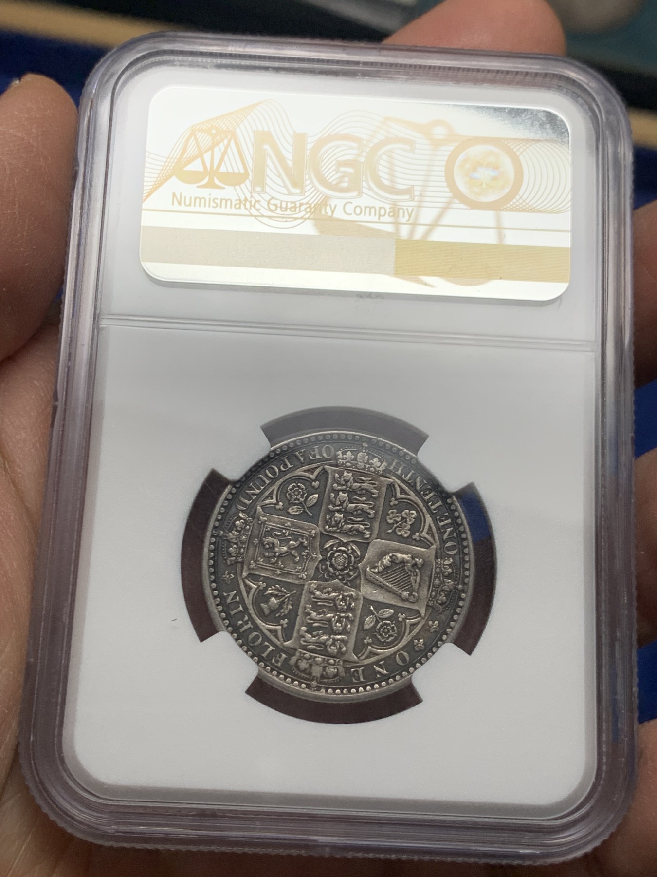 《竞宝斋》第240场-周日，周一 年终尾场 (全场包邮) NGC-AU55 英国1849年维多利亚无神弗洛林银币 英国第一枚弗洛林 第一枚没有D.G(君权神授) 正面是威廉怀恩作品 背面有代表英格兰、苏格兰、威尔士的三花 名誉品种 打制精美 五官皇冠服饰都清晰可见 特有的英系黑彩 钱币背后的故事丰富 只发行一年稀有（N家评级标签印成1949，难得的错误成了唯一）