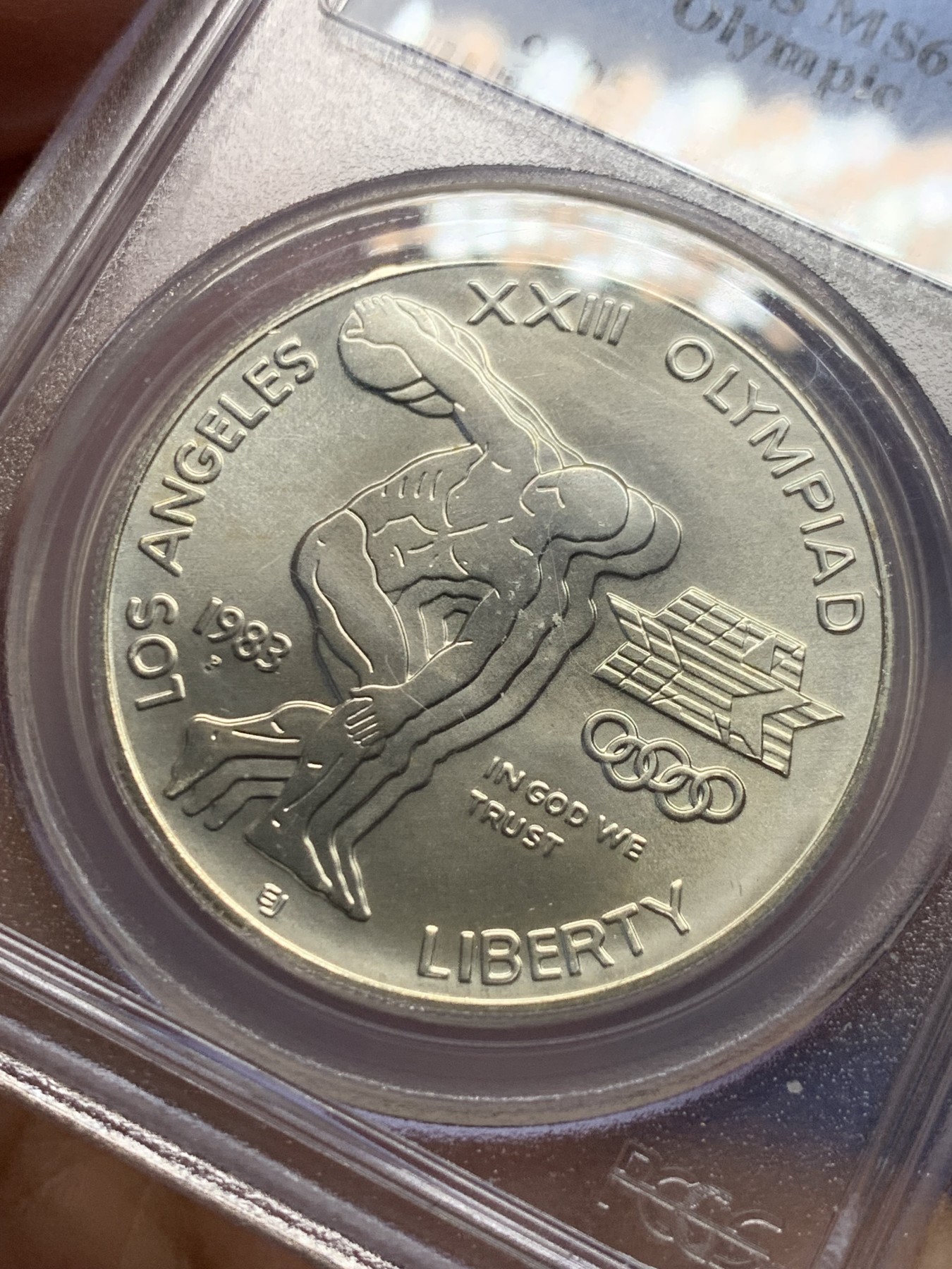 《竞宝斋》第240场-周日，周一 年终尾场 (全场包邮) PCGS-MS69 1983年美国洛杉矶奥运会掷铁饼/雄鹰1美元纪念银币，市场上常见的基本上是精制版，此币为发行量较为稀少的磨砂普制版，状态极佳，PC早期老盒严评无官网图，更高评级数量才140枚。