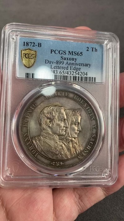 万国钱币拍卖第021期（龙年首拍） PCGS MS65 1872年德国萨克森金婚2泰勒 2泰勒的关门之作，所说好品常见，但想找到一枚此等质量的也绝非易事，双面原味均匀的包浆搭配上丝滑温润的转光令人赏心悦目。