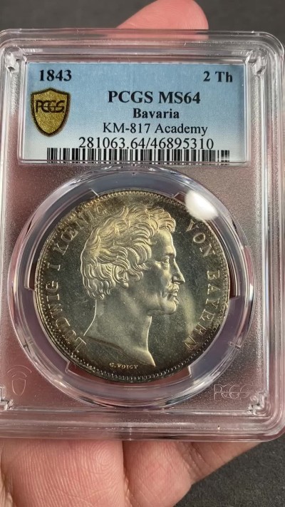 万国钱币拍卖第021期（龙年首拍） PCGS MS64 1843巴伐利亚埃尔朗根大学建校百年历史2泰勒 背面为大学创始人勃兰登堡-拜罗伊特边疆伯爵腓特烈的雕像，相当于中国古代的藩王。此枚品相状态已属顶级，镜面感极强的底板在双面淡金彩的加持下熠熠生辉，腓特烈伯爵的雕像细节一丝不苟凝于方寸之间，数百年之后辗转腾挪来到诸位手中，可能这也就是路德维希一世铸造历史的用意所在。