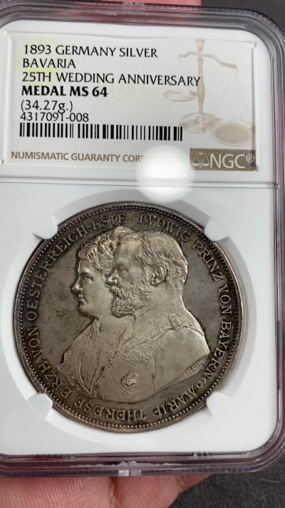万国钱币拍卖第021期（龙年首拍） NGC MS64 1893年巴伐利亚摄政王利奥波德世子结婚25周年及其子嗣2泰勒型银章，和利奥波德大桥同属一个系列，原味五彩镜面状态，想找到更好的也是不容易了。