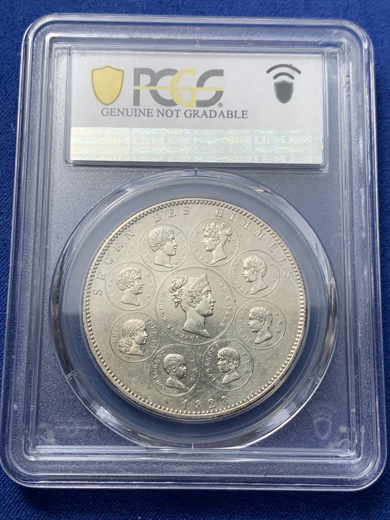 《竞宝斋》第242场-周日，周一 新年开场 (全场包邮) PCGS UNC 德国 巴伐利亚1828年祝福王室历史协定泰勒银币，直径38mm，重28.06g，纯度83.3%。背面中央为王后特蕾莎头像，其左侧为四位王子头像，右侧为四位公主头像。细节清晰状态很不错。