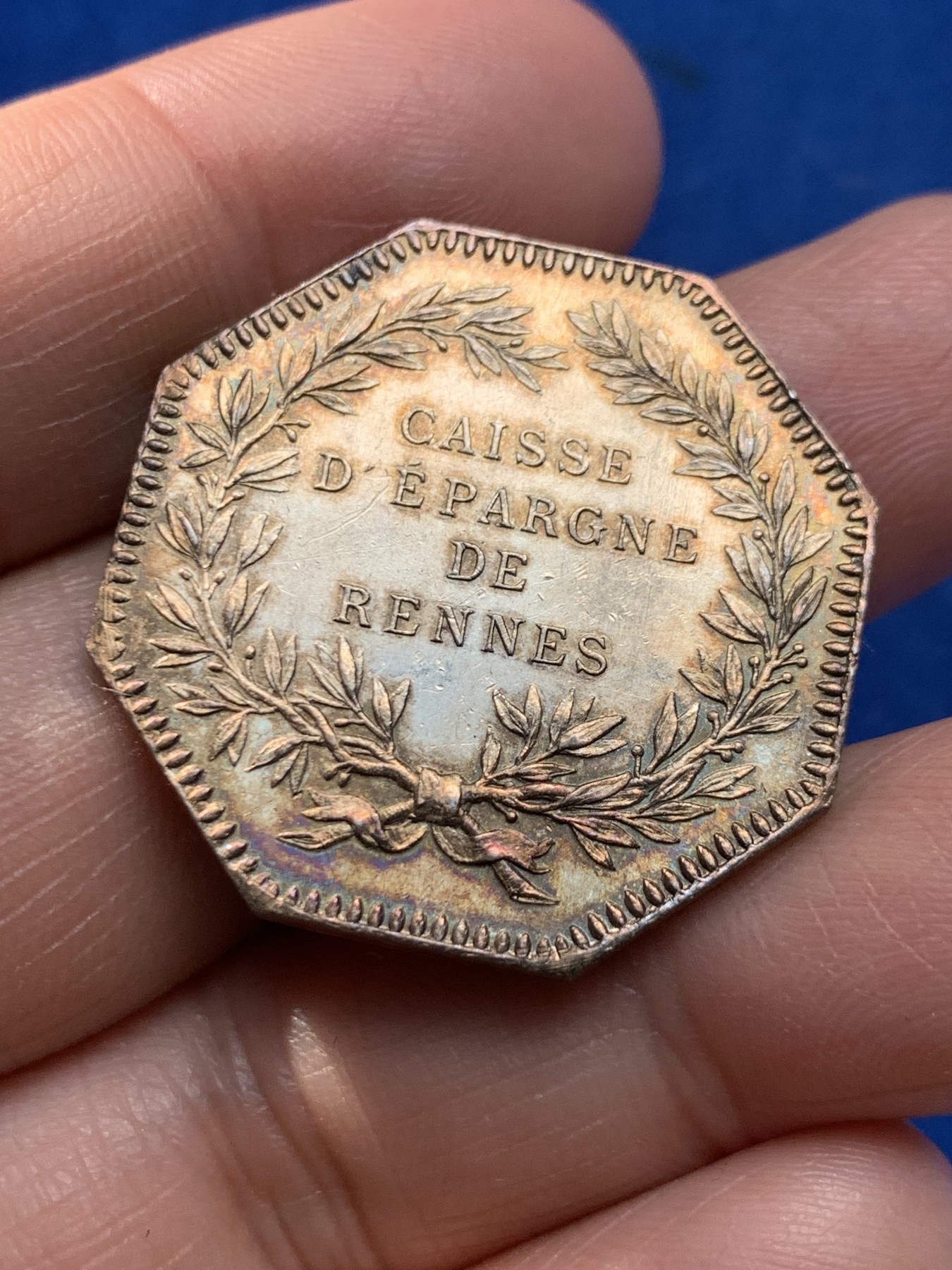 《竞宝斋》第243场-周日，周一 新年开场 (全场包邮) 法国雷恩储蓄银行八角银质代币，丰饶角边铭银标，重14.1g，直径31.4mm。正面两只身姿矫健的猎犬守护雷恩徽章，背面月桂花环围绕文字。