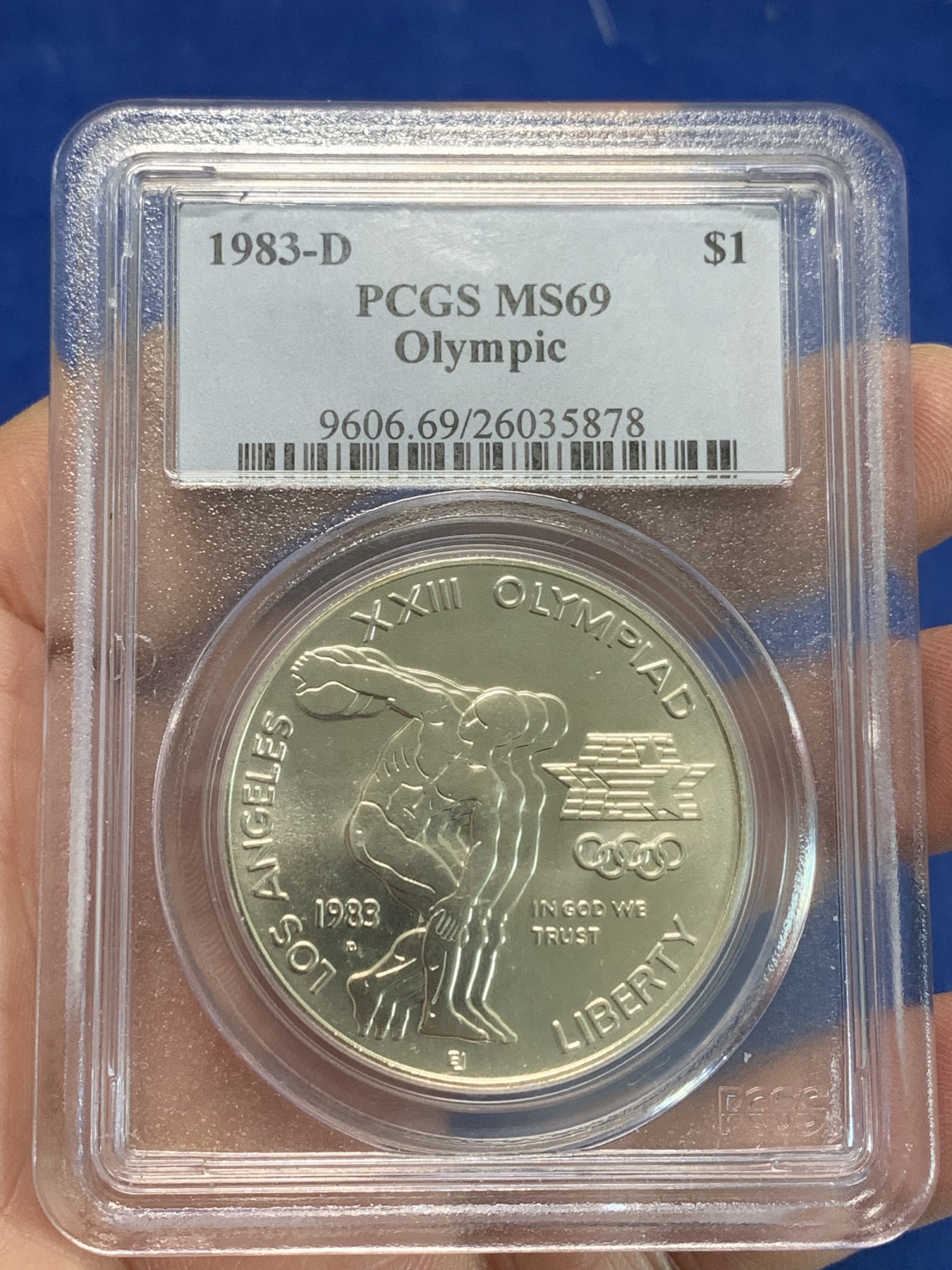 《竞宝斋》第244场-周日，周一 新年开场 (全场包邮) PCGS MS69 美国1983年D版洛杉矶奥运会掷铁饼/雄鹰1美元纪念银币，磨砂普制版，状态极佳，PC早期经典小白盒老盒无官网图，更高评级数量才52枚。