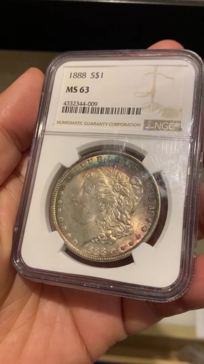 《竞宝斋》第244场-周日，周一 新年开场 (全场包邮) NGC MS63 美国1888年摩根银币，原汁原味双面环五彩包浆，状态难得。状态低评。好年份1888吉祥寓意要发发发，市场上比较稀少年份版本的摩根币。