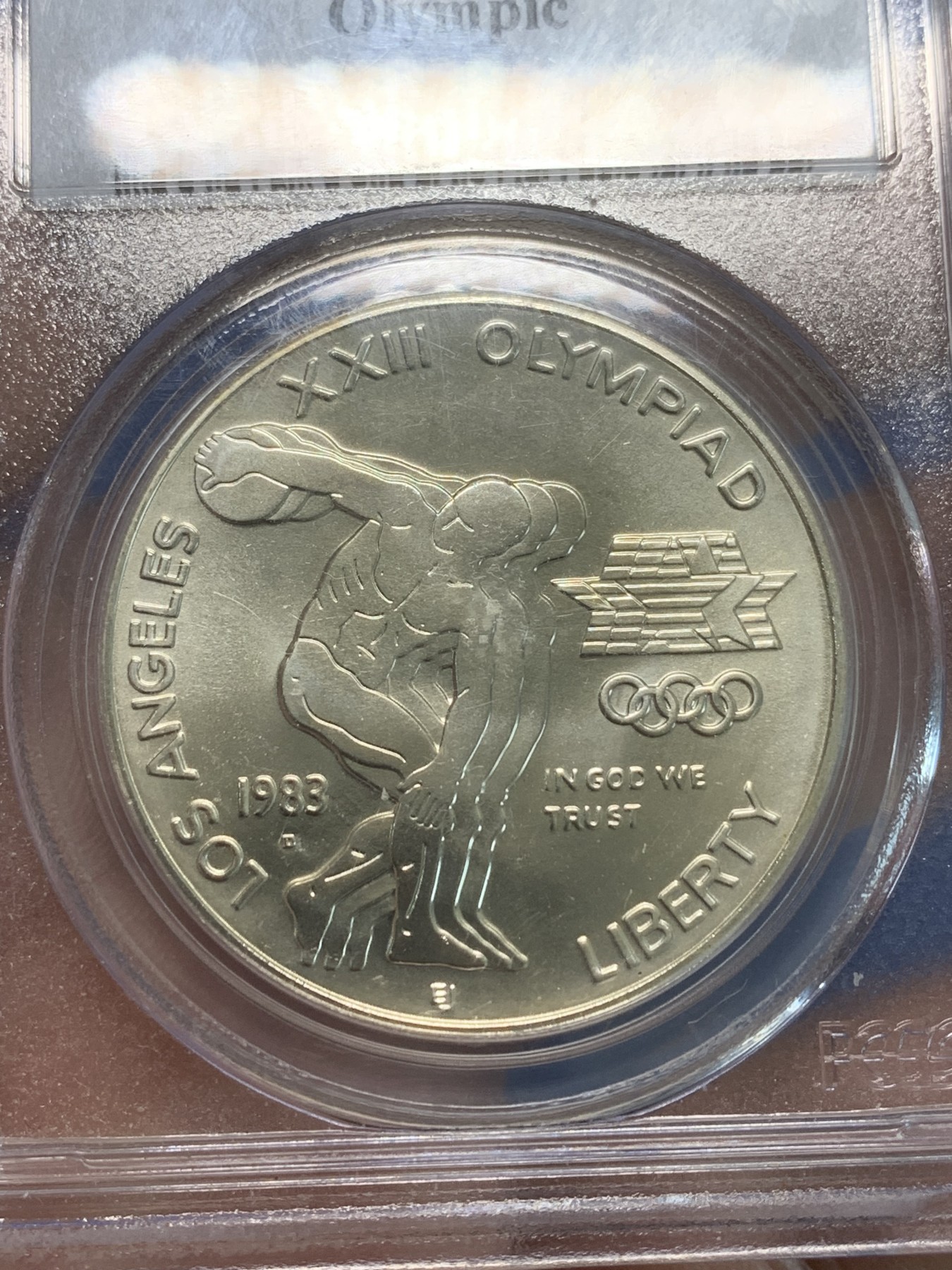 《竞宝斋》第244场-周日，周一 新年开场 (全场包邮) PCGS MS69 美国1983年D版洛杉矶奥运会掷铁饼/雄鹰1美元纪念银币，磨砂普制版，状态极佳，PC早期经典小白盒老盒无官网图，更高评级数量才52枚。