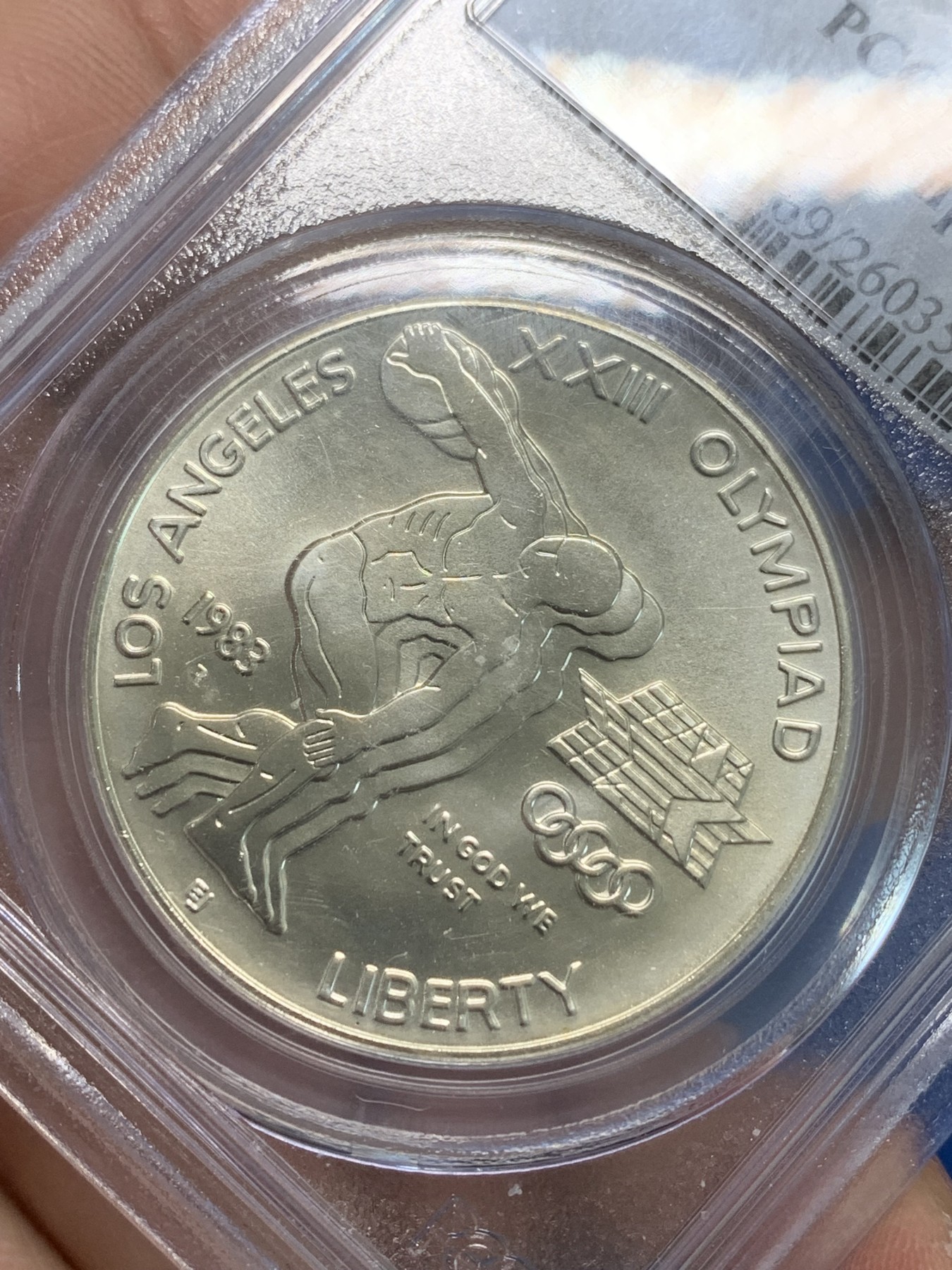 《竞宝斋》第244场-周日，周一 新年开场 (全场包邮) PCGS MS69 美国1983年D版洛杉矶奥运会掷铁饼/雄鹰1美元纪念银币，磨砂普制版，状态极佳，PC早期经典小白盒老盒无官网图，更高评级数量才52枚。