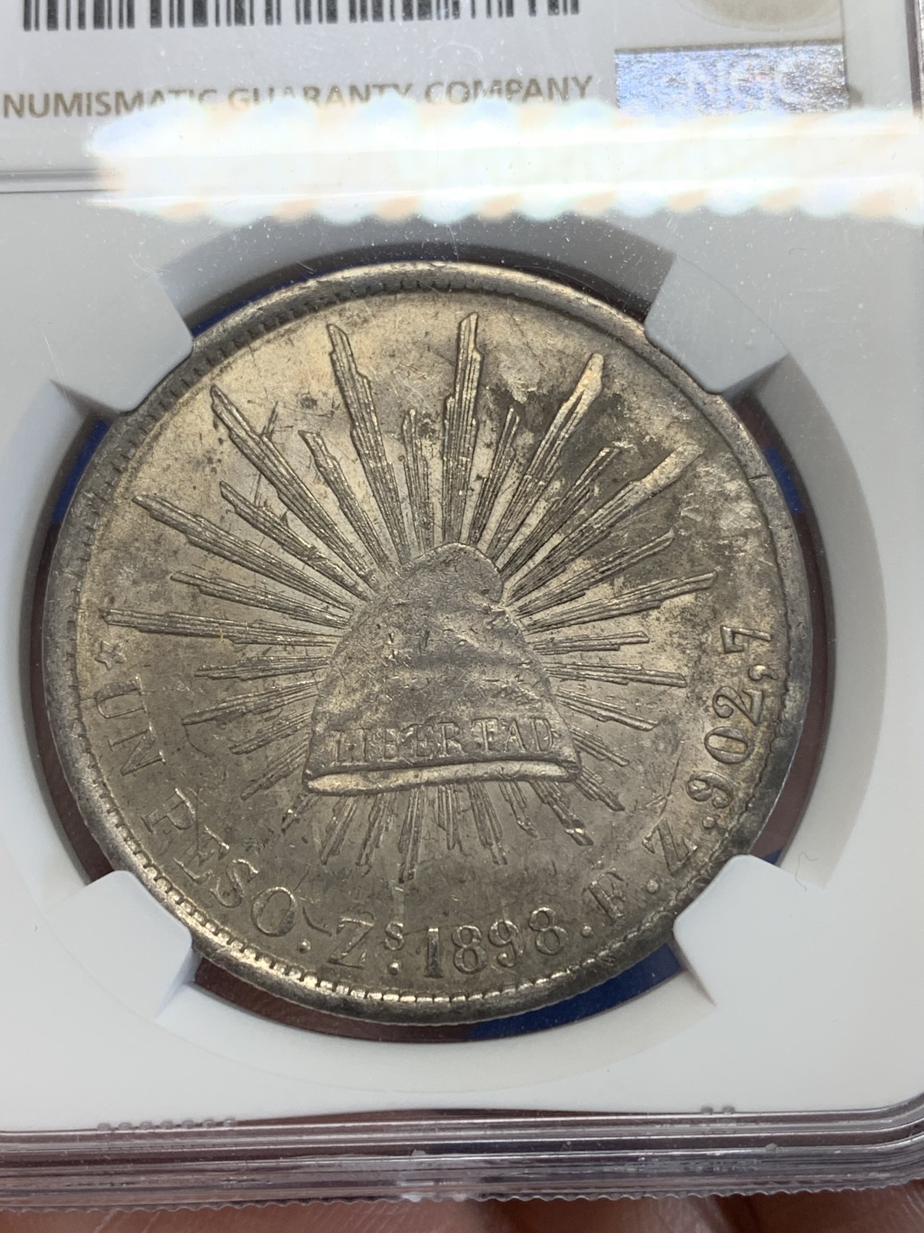 《竞宝斋》第245场-周日，周一 ，周二3场连拍 (全场包邮) NGC-AUD 墨西哥1898年ZS FZ直边鹰洋1比索银币，原汁原味老包浆，包浆醇厚，打制精美，状态极佳，经典潜力品种。