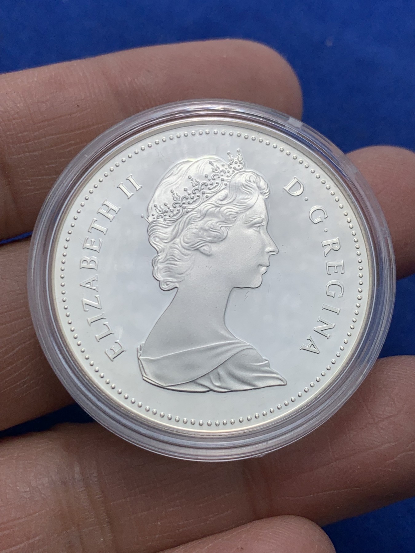 《竞宝斋》第247场-周日，周一 ，周二3场连拍 (全场包邮) 1984年加拿大多伦多市成立100周年纪念精制银币，直径36mm ，重23.3g 。正面为伊丽莎白二世女王年轻时右向胸像，背面为水面划船的印第安人背景为多伦多轮廓。全新原盒带证书镜面类精制银币，状态极佳。