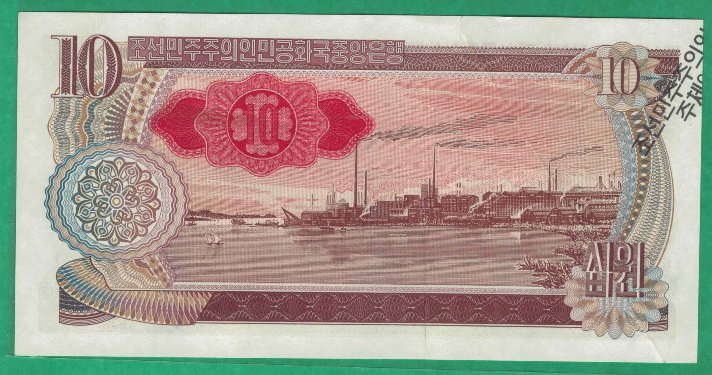 朝鲜1978年(2003年)10元 纪念钞 珍罕错钞 实物图 八五品 祥见备注：朝鲜1978年(2003年)10元 错版纪念钞 黑朝文 红号码 背红印，该钞在加印纪念文字时，由于纸币发生折叠，因此造成纪念文字前部分在钞票背面，后部分在钞票正面的情况，十分罕见。