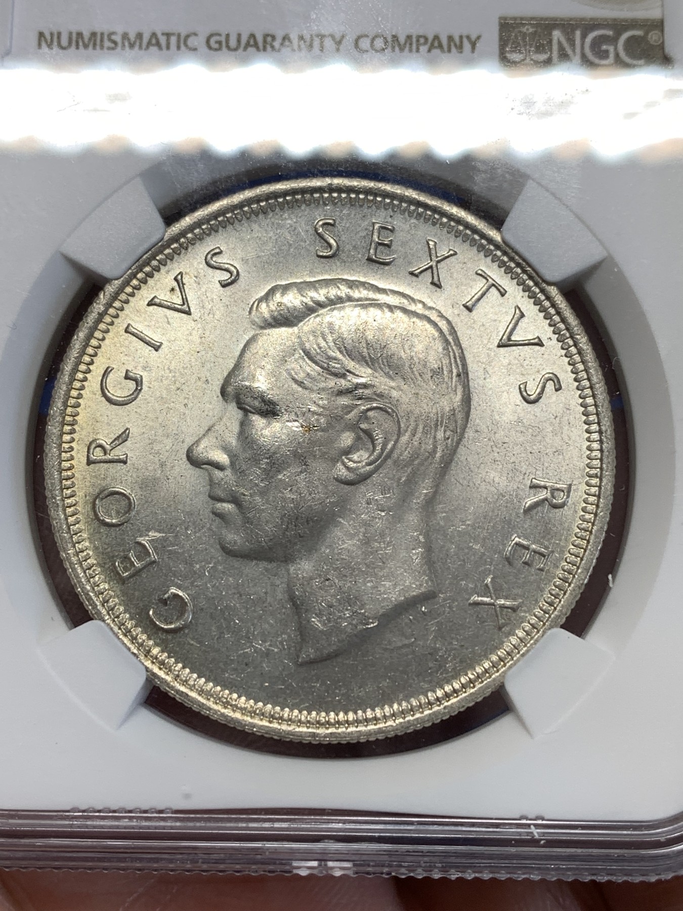 《竞宝斋》第251场-周日，周一2场连拍 (全场包邮) NGC MS61 英属南非1952年乔治六世5先令克朗型大银币 原光充沛，银光闪闪，背面带环彩，略有低评。