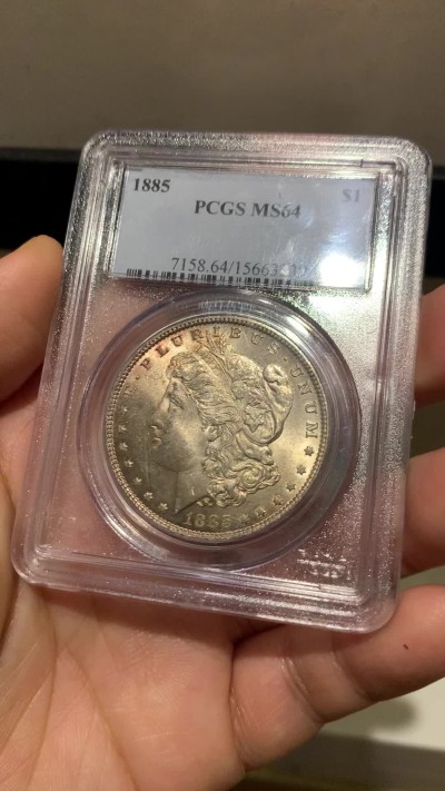 《竞宝斋》第253场-周日，周一，周二 3场连拍 (全场包邮) PCGS MS64 美国1885年摩根银币O版，币面清爽干净又漂亮，打制精美，状态一流，PC经典小白盒严评无官网图。