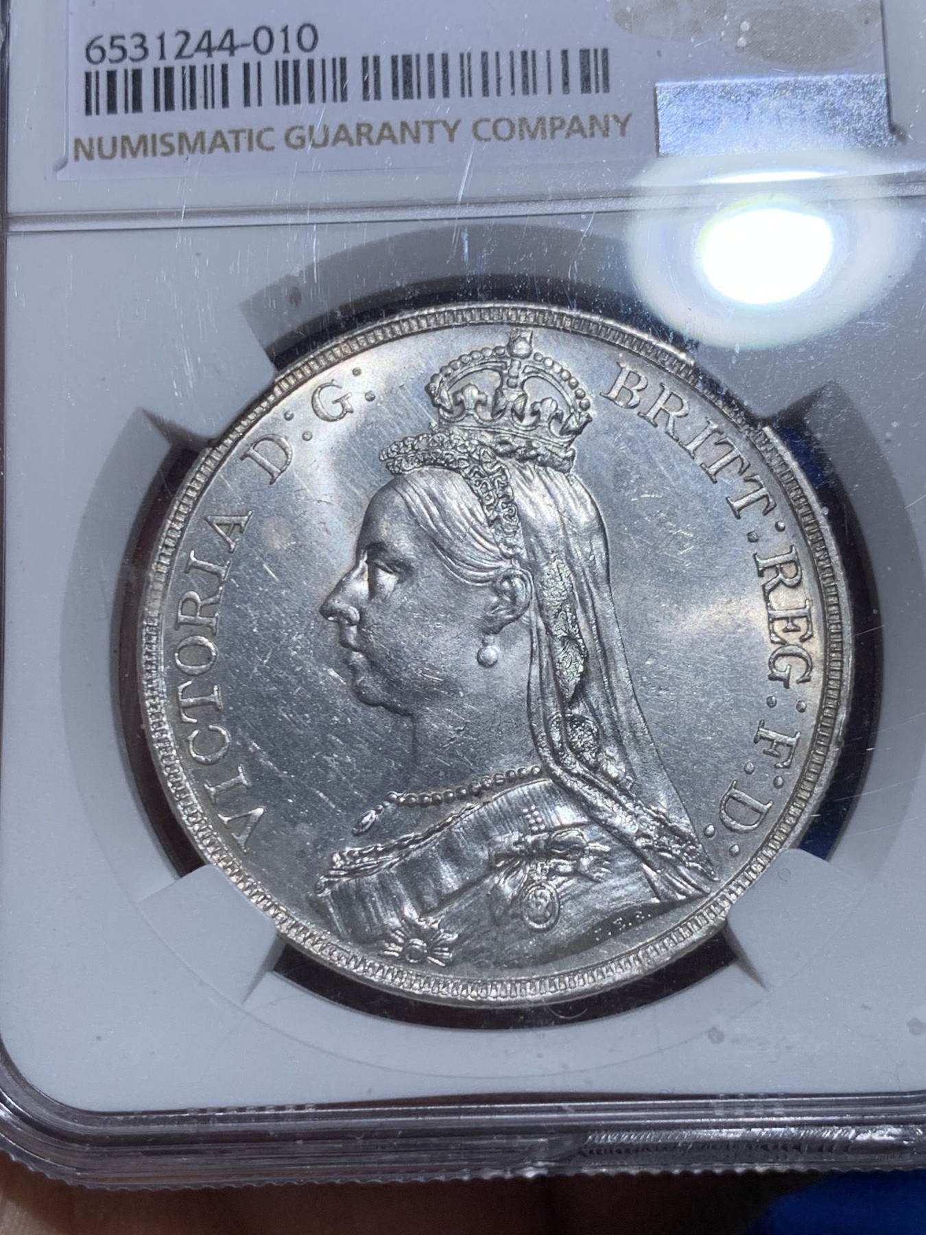 《竞宝斋》第256场-周日，周一 2场连拍 (全场包邮) NGC MS61 英国1890年维多利亚女王高冠马剑1克朗，镜面底板，干净漂亮。盒子下边缘有损。