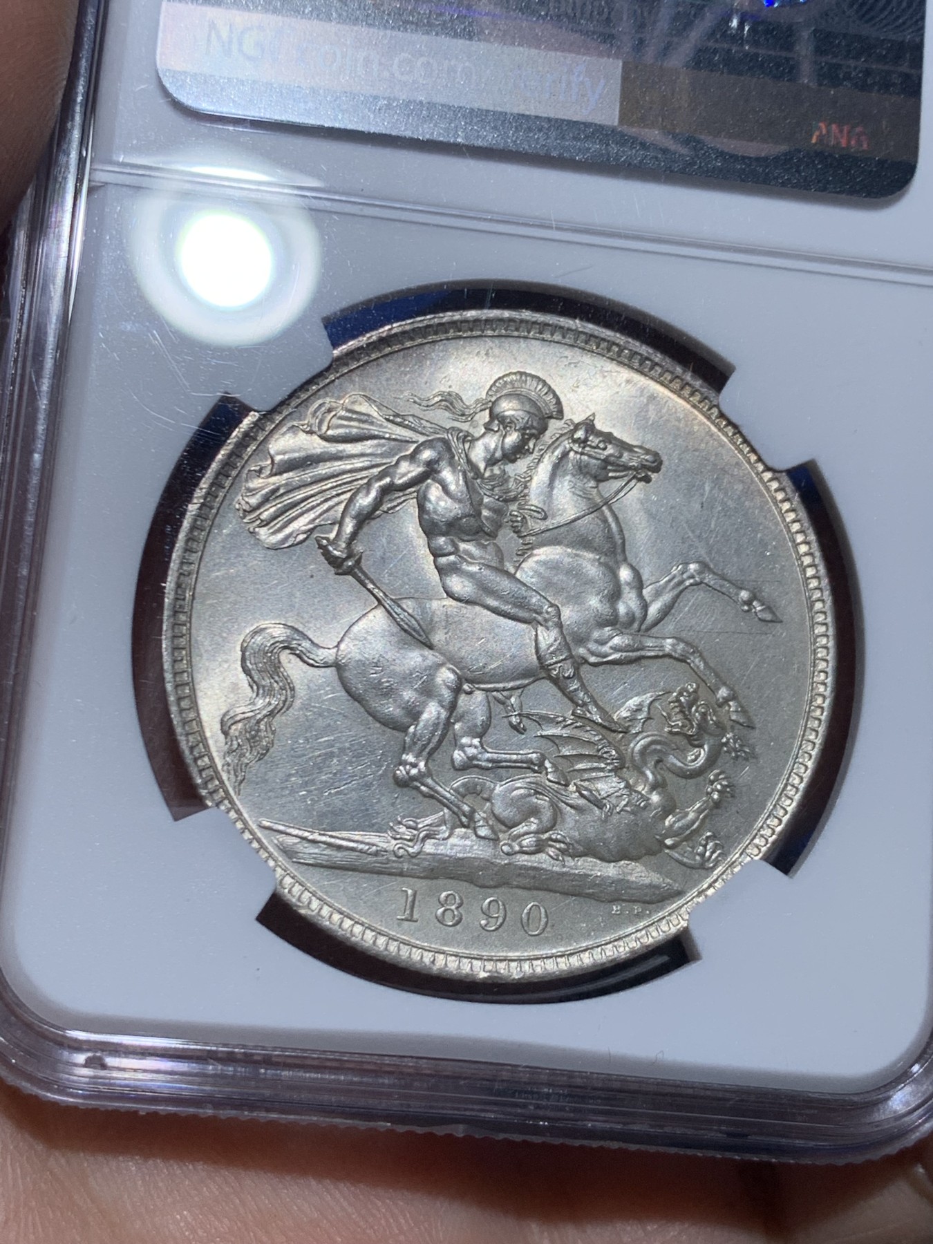 《竞宝斋》第256场-周日，周一 2场连拍 (全场包邮) NGC MS61 英国1890年维多利亚女王高冠马剑1克朗，镜面底板，干净漂亮。盒子下边缘有损。