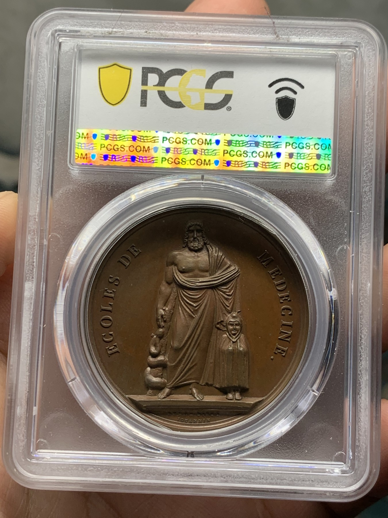 《竞宝斋》第257场-周日，周一 2场连拍 (全场包邮) PCGS SP64 亚军分 法国1805年拿破仑一世原铸医神铜章 医神阿斯克勒庇俄斯左手持缠绕着蛇的手杖 ，右手抚戴着斗篷的儿子康复之神泰勒夫鲁斯，他正为治疗疾病沉思，一条毒蛇悄悄地盘绕在他手杖上，他把蛇杀死后又出现一条毒蛇，口衔药草，使头一条死蛇得以复活，于是他的蛇杖成为医学的标志