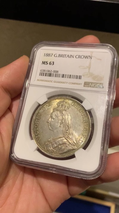 《竞宝斋》第257场-周日，周一 2场连拍 (全场包邮) NGC MS63 英国1887年维多利亚女王高冠马剑1克朗，两面淡彩包浆使浮雕更加生动，非常漂亮。