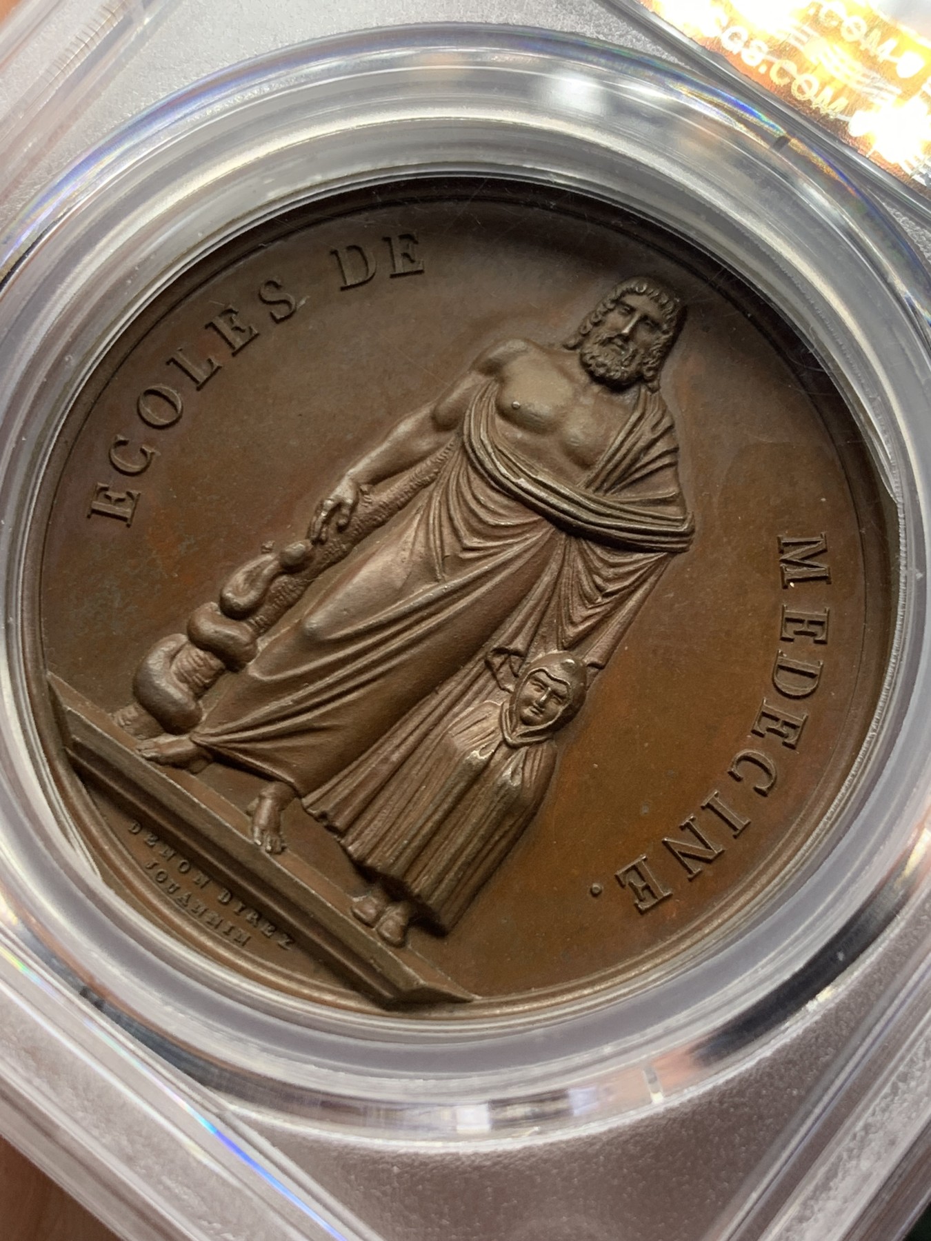 《竞宝斋》第257场-周日，周一 2场连拍 (全场包邮) PCGS SP64 亚军分 法国1805年拿破仑一世原铸医神铜章 医神阿斯克勒庇俄斯左手持缠绕着蛇的手杖 ，右手抚戴着斗篷的儿子康复之神泰勒夫鲁斯，他正为治疗疾病沉思，一条毒蛇悄悄地盘绕在他手杖上，他把蛇杀死后又出现一条毒蛇，口衔药草，使头一条死蛇得以复活，于是他的蛇杖成为医学的标志