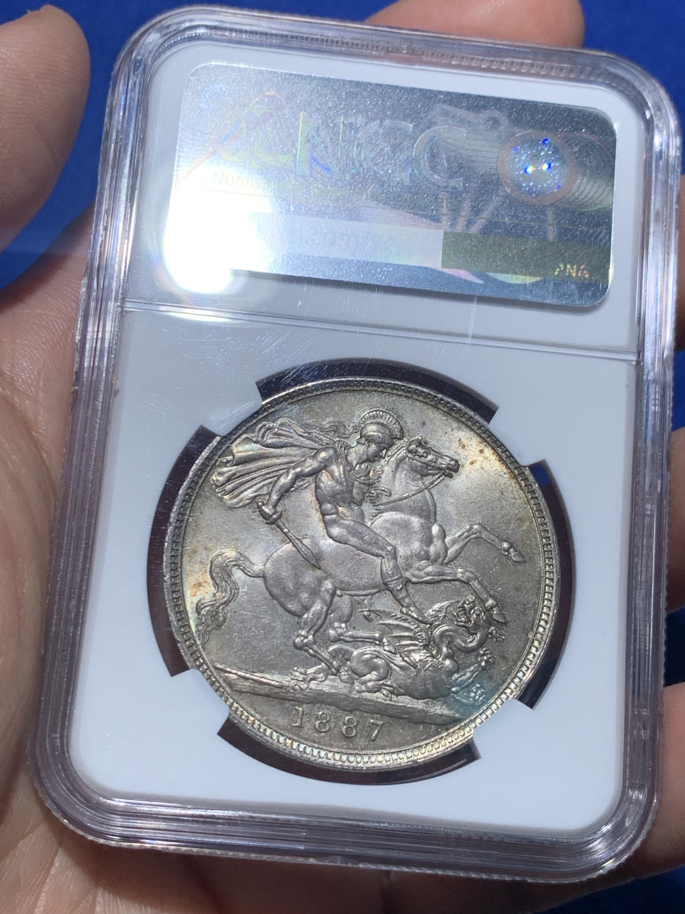 《竞宝斋》第257场-周日，周一 2场连拍 (全场包邮) NGC MS63 英国1887年维多利亚女王高冠马剑1克朗，两面淡彩包浆使浮雕更加生动，非常漂亮。