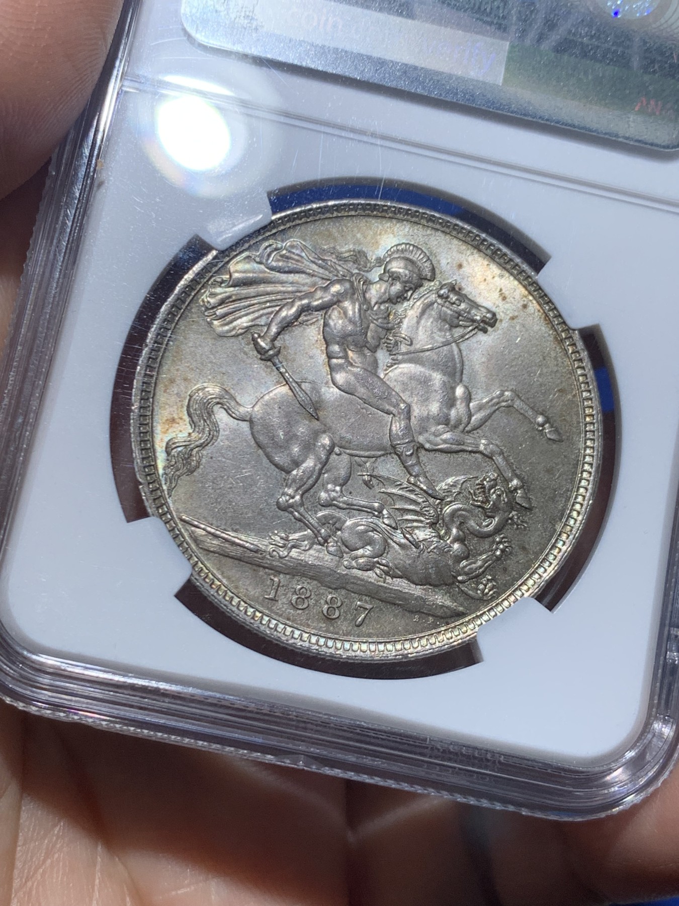 《竞宝斋》第257场-周日，周一 2场连拍 (全场包邮) NGC MS63 英国1887年维多利亚女王高冠马剑1克朗，两面淡彩包浆使浮雕更加生动，非常漂亮。