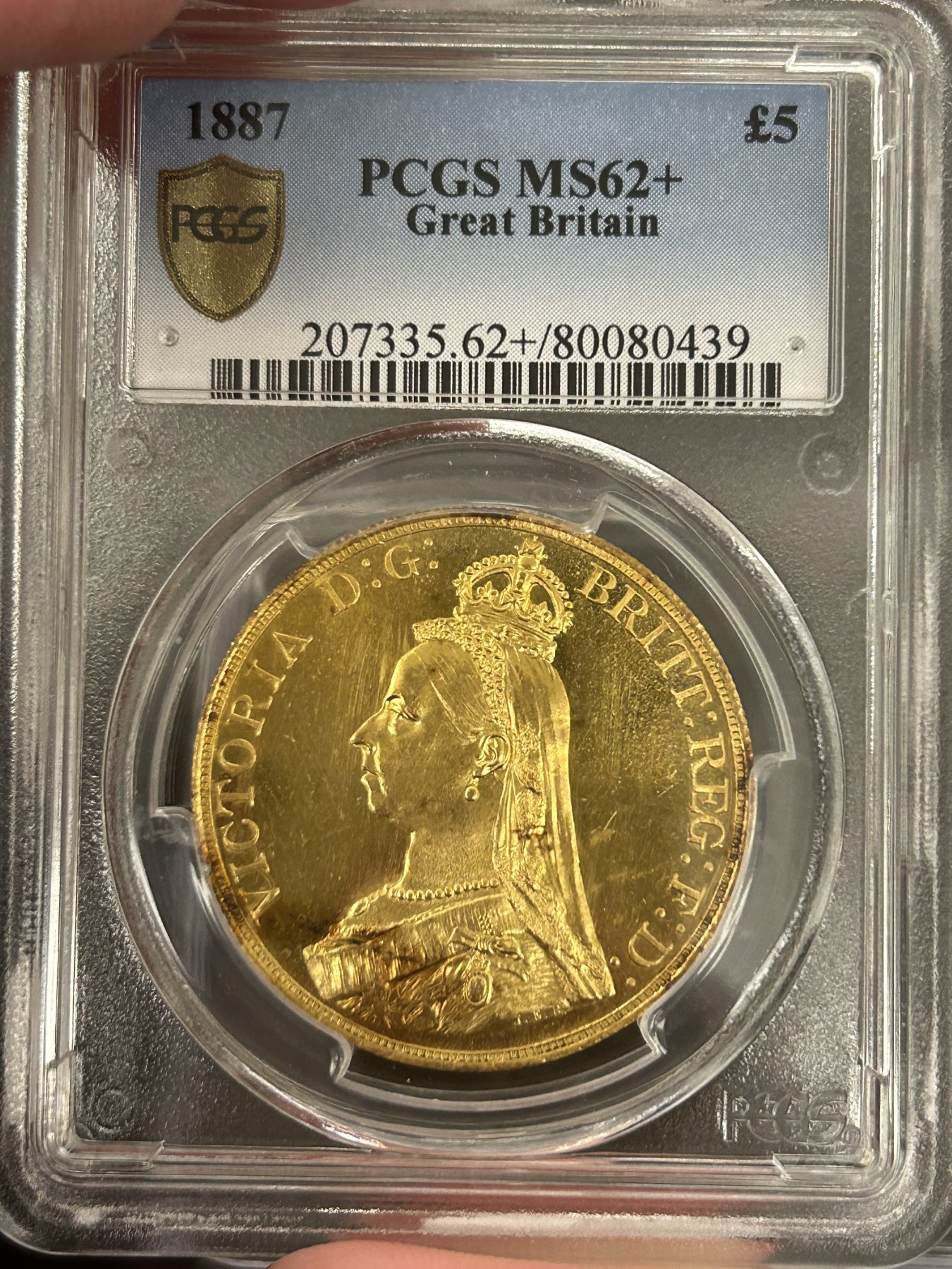 万国钱币拍卖第023期（金辉银韵之夜） PCGS MS62+ 1887英国维多利亚女王5镑金币 发行量54000枚，近40g的重量足以在流通金币当中傲视群雄，黄金的闪耀与经典的圣乔治屠龙完美结合，此枚打制深峻，底板类镜面质感，光泽强烈，在黄金暴涨的大环境下，堪称投资与收藏的双赢之选，再高半分的价格可能就是另一个档次的存在，此次入手机会切勿错过。