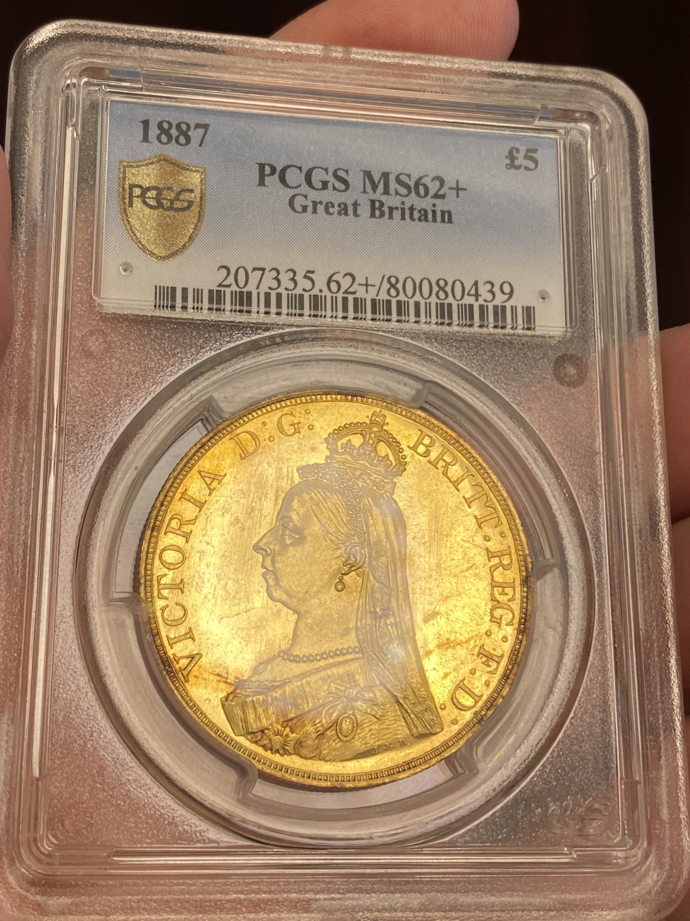 万国钱币拍卖第023期（金辉银韵之夜） PCGS MS62+ 1887英国维多利亚女王5镑金币 发行量54000枚，近40g的重量足以在流通金币当中傲视群雄，黄金的闪耀与经典的圣乔治屠龙完美结合，此枚打制深峻，底板类镜面质感，光泽强烈，在黄金暴涨的大环境下，堪称投资与收藏的双赢之选，再高半分的价格可能就是另一个档次的存在，此次入手机会切勿错过。