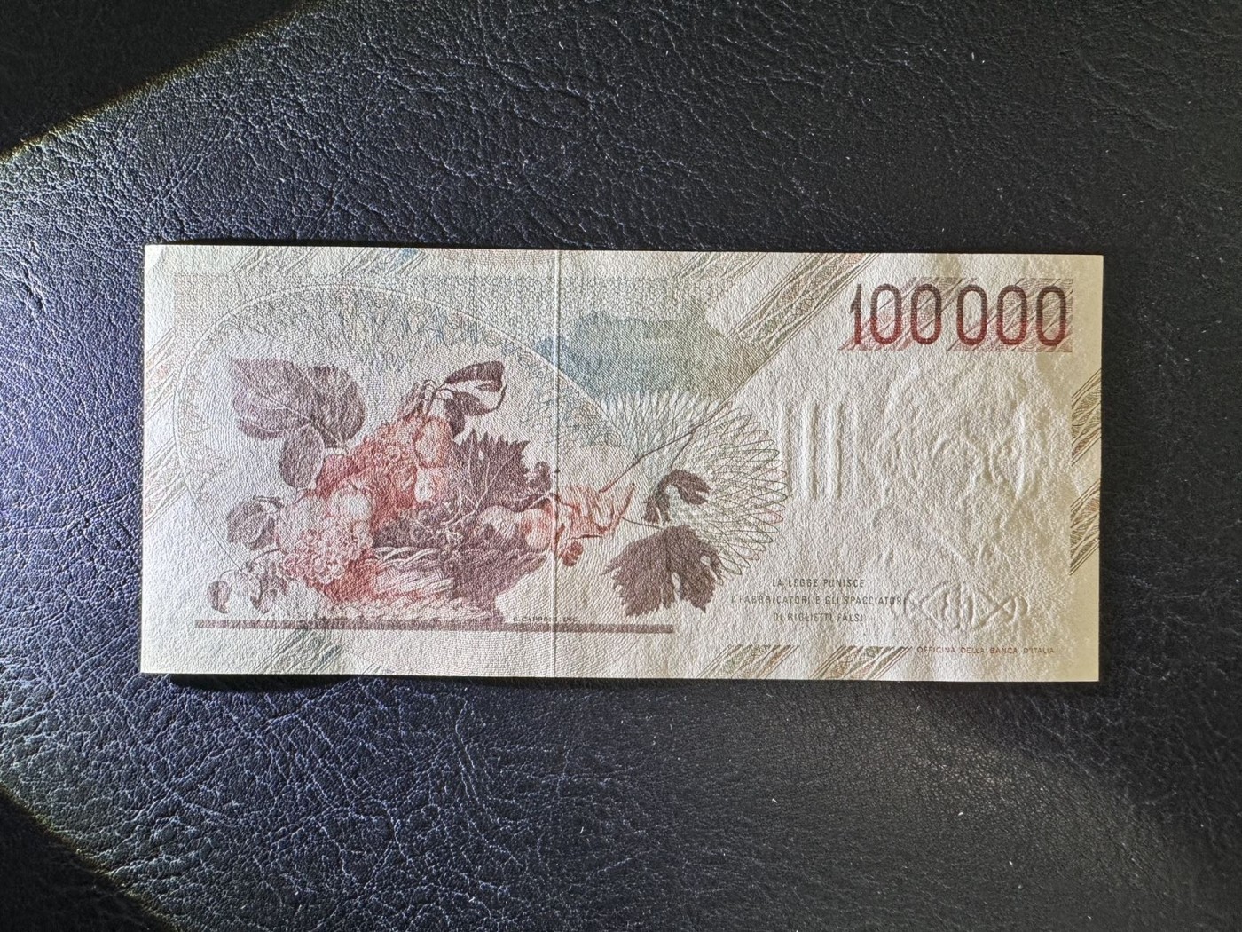 收藏联盟Quantum Auction 第337期拍卖  意大利1983年100000里拉 品相UNC 角有瑕疵 细节如图  拉瓦乔名画《占卜者》和《一蓝水果》 