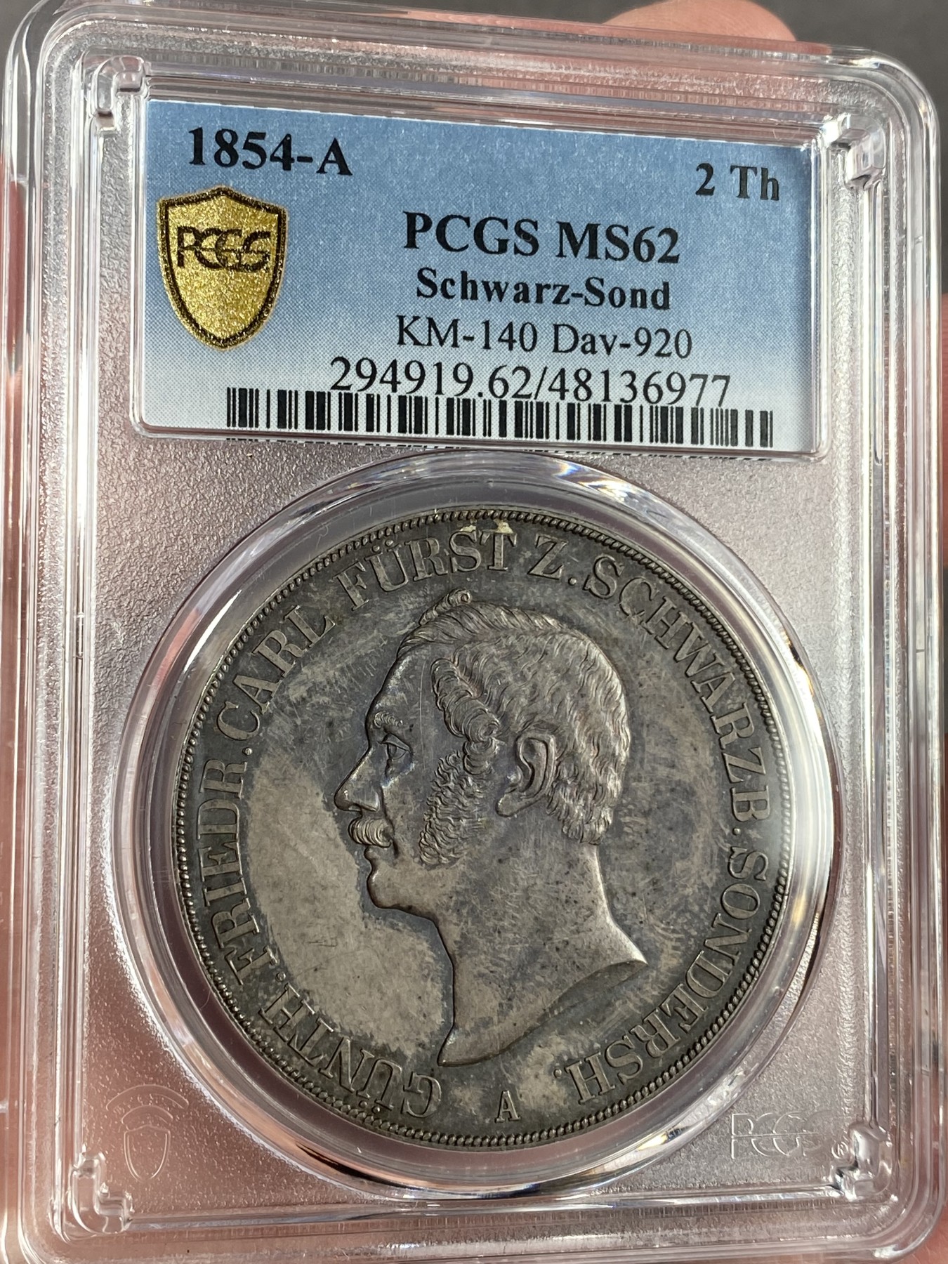 万国钱币拍卖第024期（诸神之战） PCGS MS62 1854年德国施瓦茨堡-桑德斯豪森野人2泰勒 可能是所有德国币爱好者都想拥有的品种，堪称德邦时期2泰勒的代表之作，独特的纹章设计令人过目难忘，无奈发行量少得可怜，留下的好品更是寥寥，注定只能流入少数藏家之手。此枚分数虽算不上顶级，但状态异常亮眼，双面醇厚的老五彩包浆和几乎无磨损的高点相得益彰，底板整洁无伤，绝对可堪入藏的一枚。