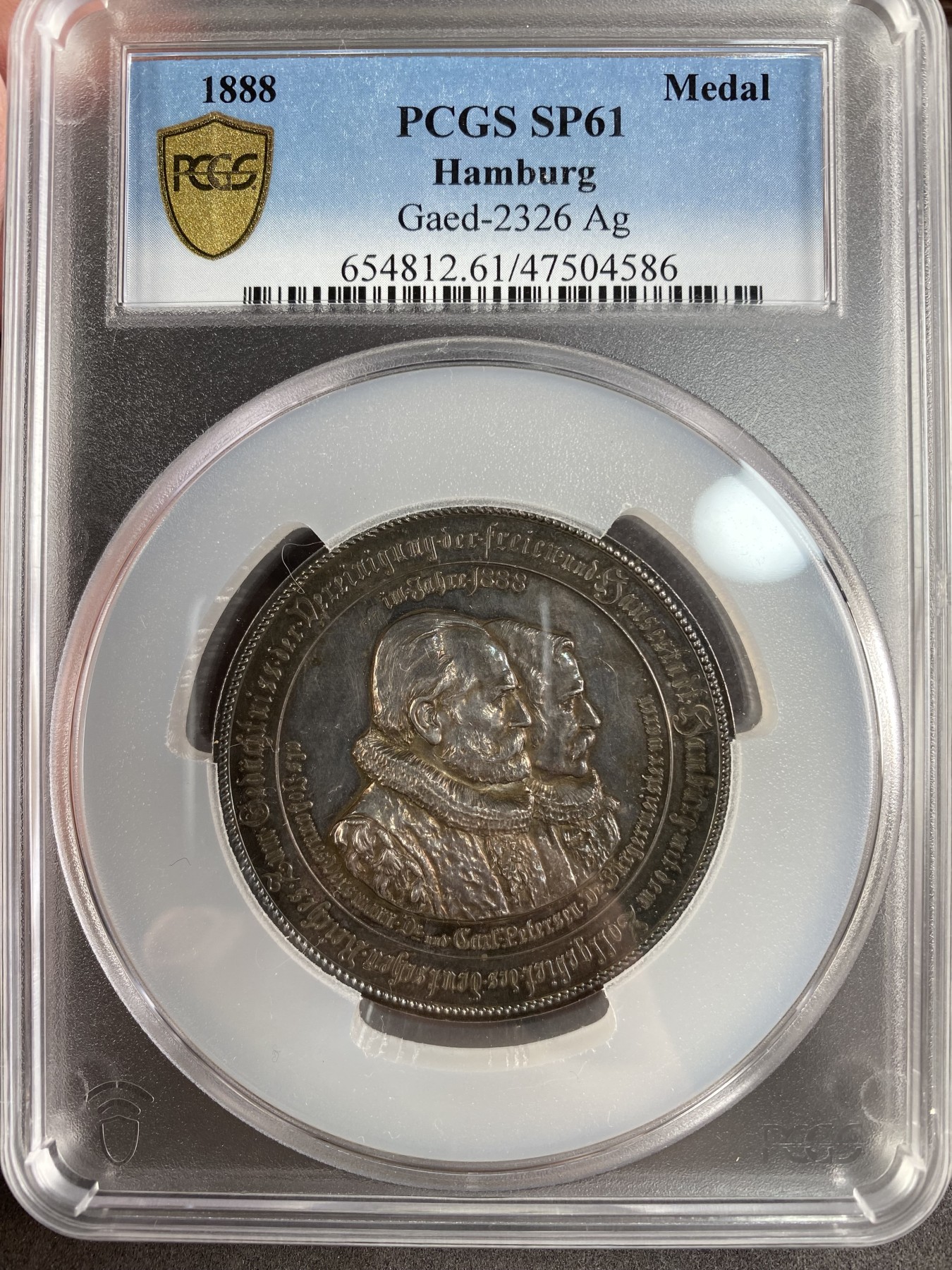 万国钱币拍卖第024期（诸神之战） PCGS SP61 德国1888年汉堡自由市与帝国关税区统一纪念五彩大银章 55mm 60g 正面为汉堡市长威斯曼和皮特森 背面为汉堡海关大楼与港口景观 极其漂亮 