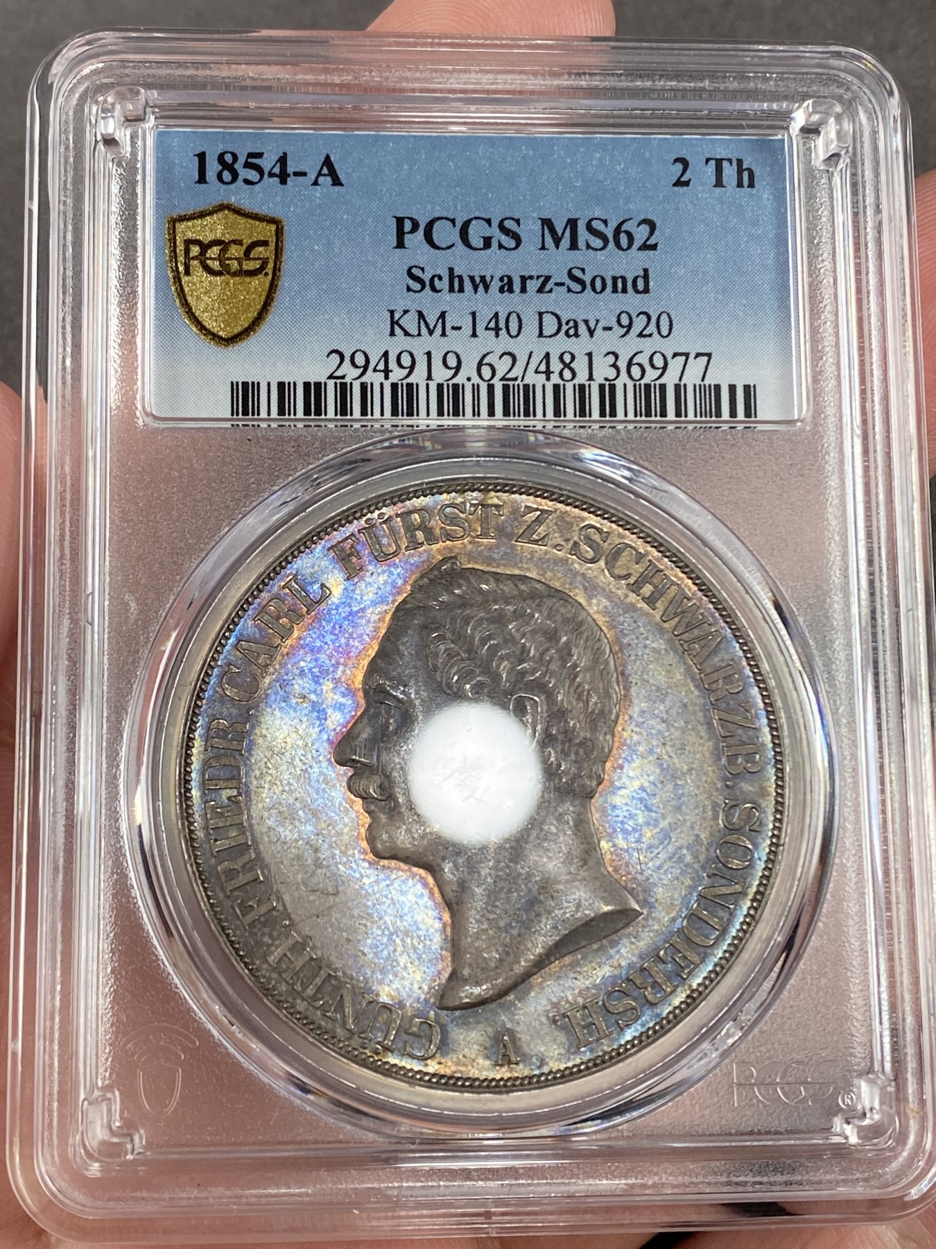 万国钱币拍卖第024期（诸神之战） PCGS MS62 1854年德国施瓦茨堡-桑德斯豪森野人2泰勒 可能是所有德国币爱好者都想拥有的品种，堪称德邦时期2泰勒的代表之作，独特的纹章设计令人过目难忘，无奈发行量少得可怜，留下的好品更是寥寥，注定只能流入少数藏家之手。此枚分数虽算不上顶级，但状态异常亮眼，双面醇厚的老五彩包浆和几乎无磨损的高点相得益彰，底板整洁无伤，绝对可堪入藏的一枚。