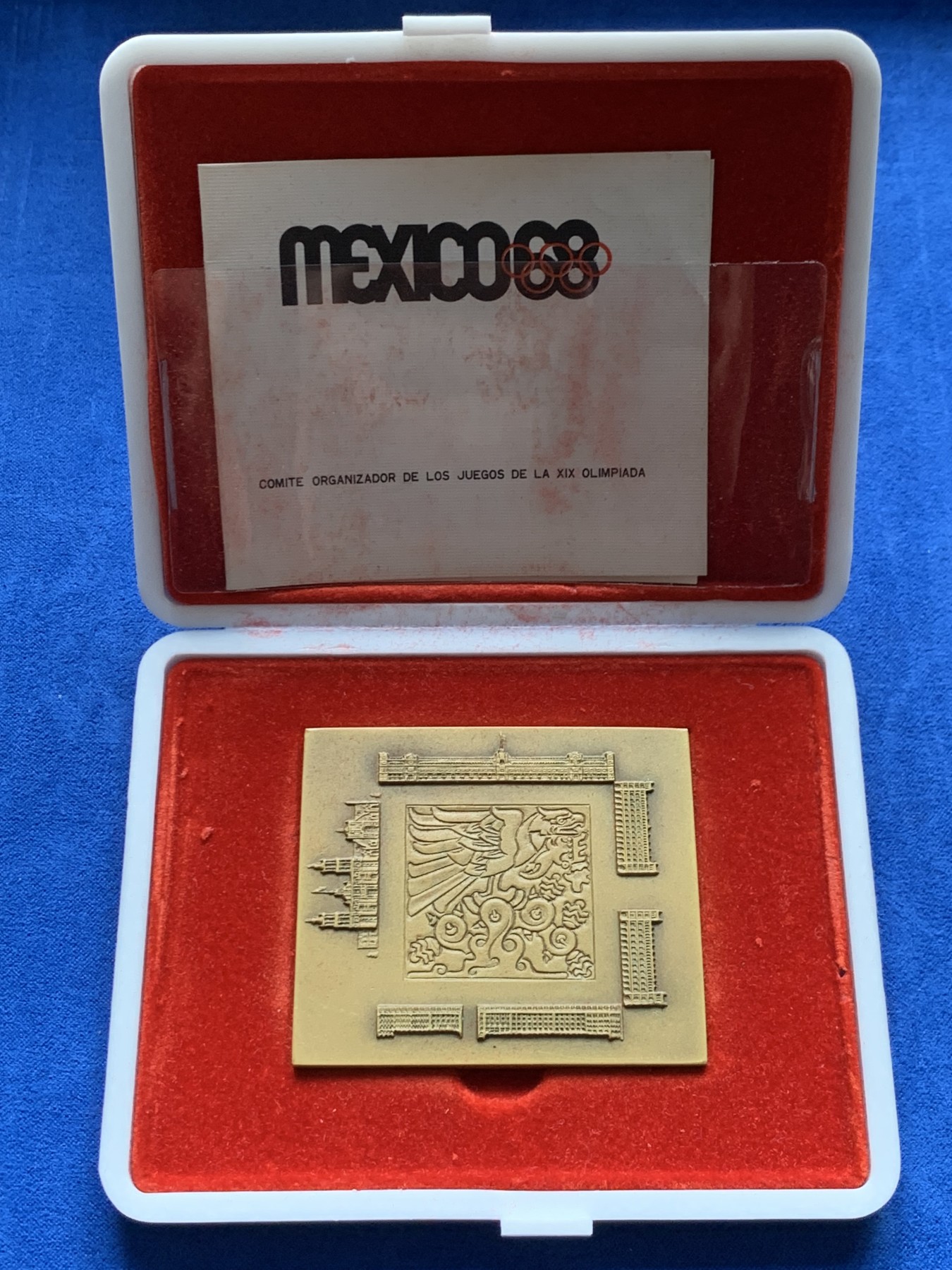 《竞宝斋》第263场-周日，周一 2场连拍 (全场包邮) 墨西哥1968年奥运会纪念方形铜章，原盒原证，NO.530，正面图案为墨西哥瓦哈卡大教堂、古城建筑及墨西哥古代图腾