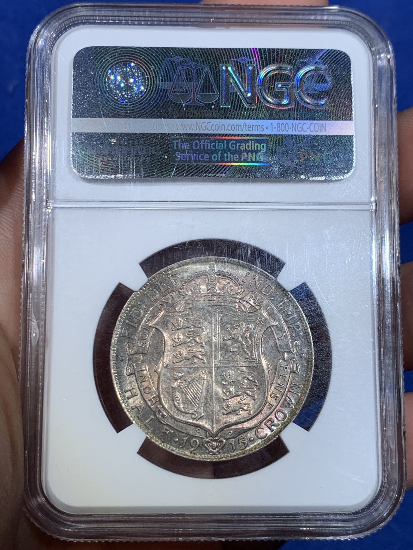 《竞宝斋》第264场-周日，周一 2场连拍 (全场包邮) NGC MS63 英国1915年乔治五世1/2克朗银币，正面转光，背面五彩。高银盾徽版本，流通充分，高分不多。高品质英国老币稀少