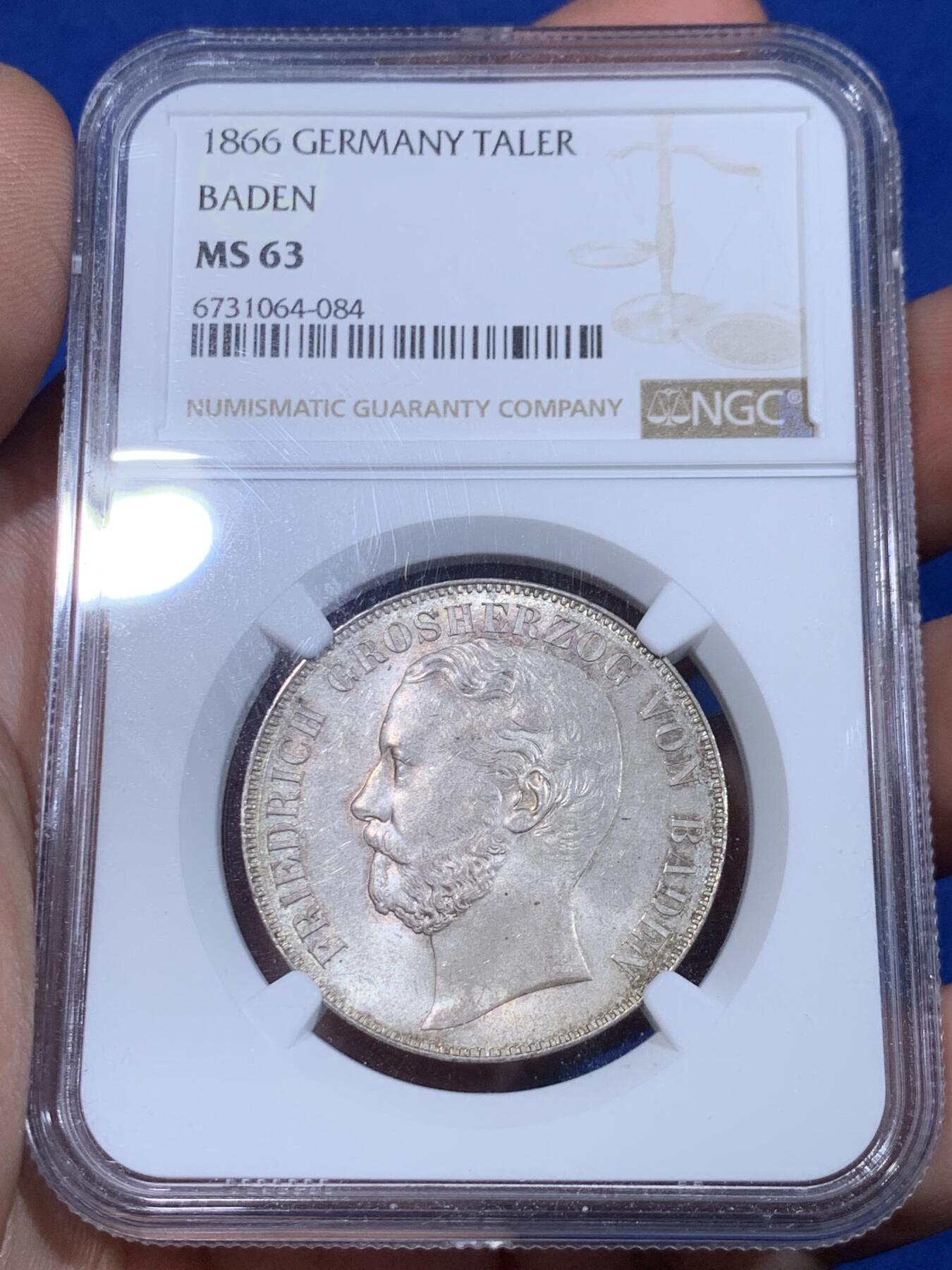 《竞宝斋》立夏专场特拍 （第2-1场）全场顺丰包邮 265场 NGC MS63 德国1866年巴登-杜拉赫公国1泰勒 该品种流通充分好品难寻 背面为经典的双狮鹫徽章 这枚全深打 整体细节和光度都很好 欧洲纸袋老包浆