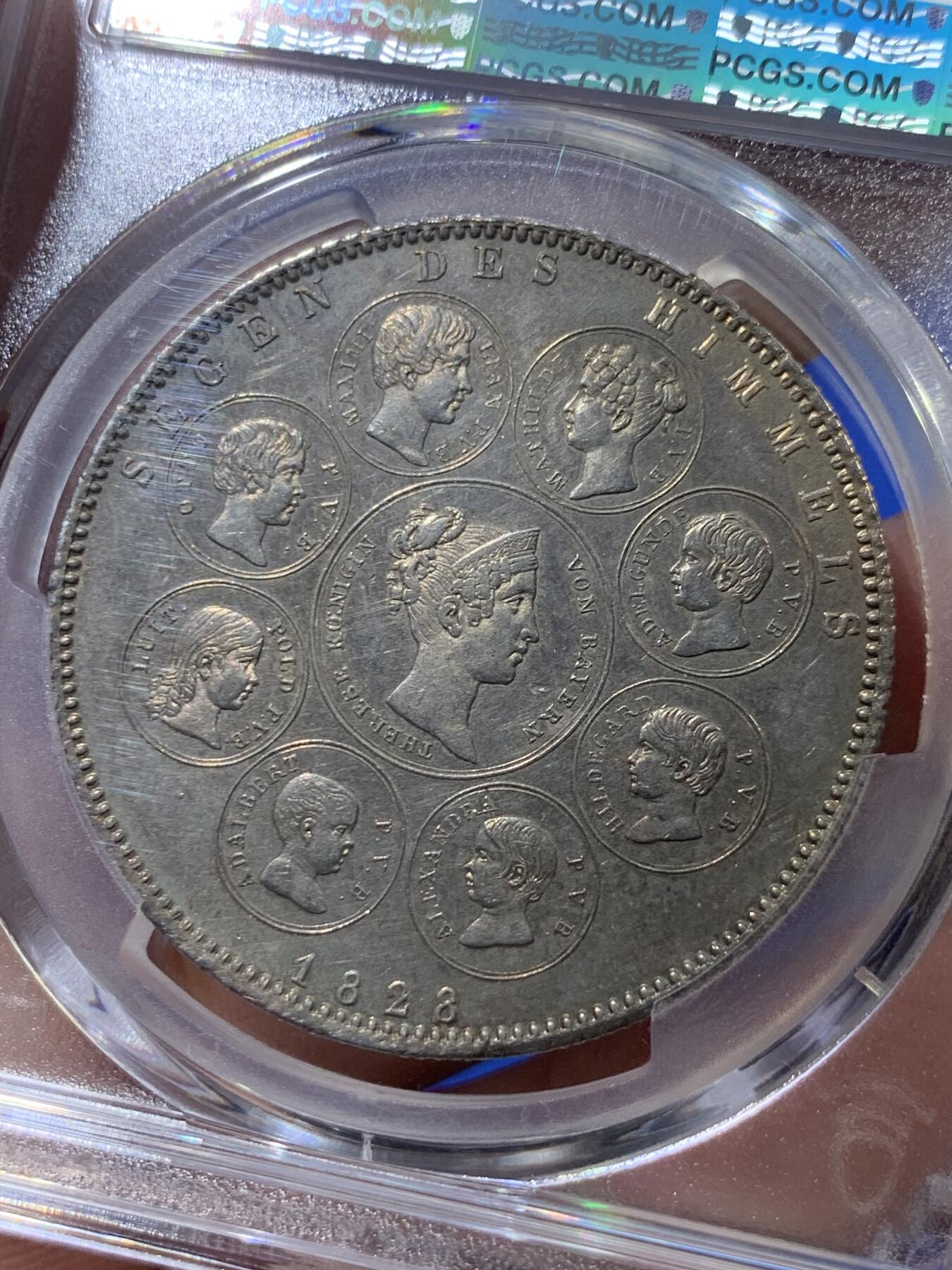 《竞宝斋》立夏专场特拍 （第2-1场）全场顺丰包邮 265场 PCGS UNC 德国 巴伐利亚1828年祝福王室历史协定泰勒银币，直径38mm，重28.06g，纯度83.3%。背面中央为王后特蕾莎头像，其四周是八位子女头像。细节清晰状态很不错。