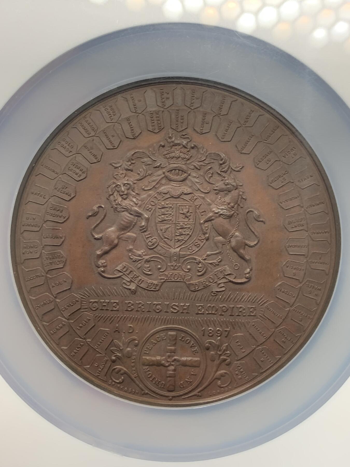 《竞宝斋》立夏专场特拍 （第2-1场）全场顺丰包邮 265场 NGC MS61BN 英国1897维多利亚钻石周年纪念铜章 大盒加厚 76MM 背后是双手合呈十字形，写着爱 和平 和 联合 55个盾牌上是英国领土以及殖民地名称 彰显日不落帝国的辉煌 也是英国帝国全球扩张的历史见证