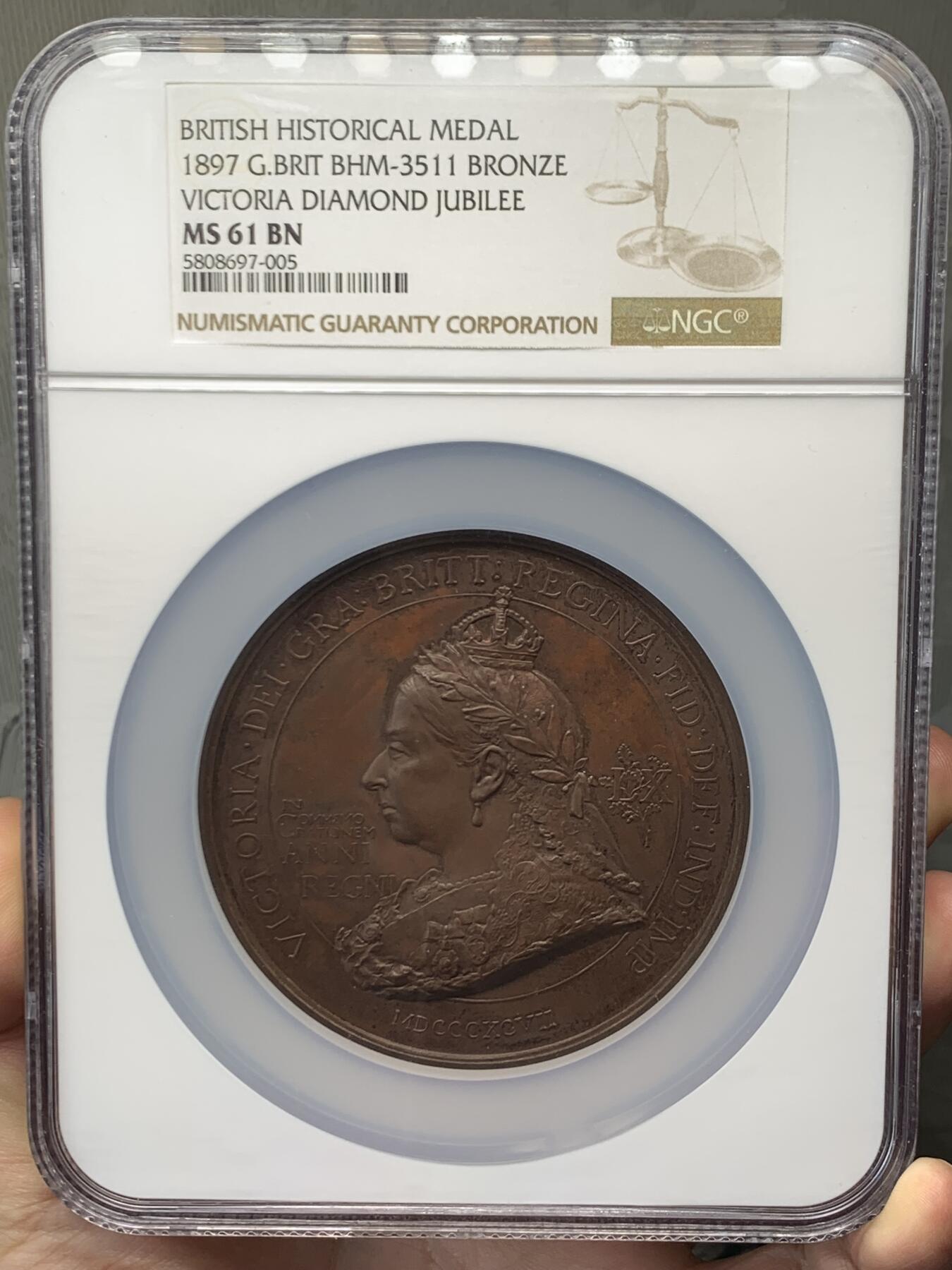 《竞宝斋》立夏专场特拍 （第2-1场）全场顺丰包邮 265场 NGC MS61BN 英国1897维多利亚钻石周年纪念铜章 大盒加厚 76MM 背后是双手合呈十字形，写着爱 和平 和 联合 55个盾牌上是英国领土以及殖民地名称 彰显日不落帝国的辉煌 也是英国帝国全球扩张的历史见证