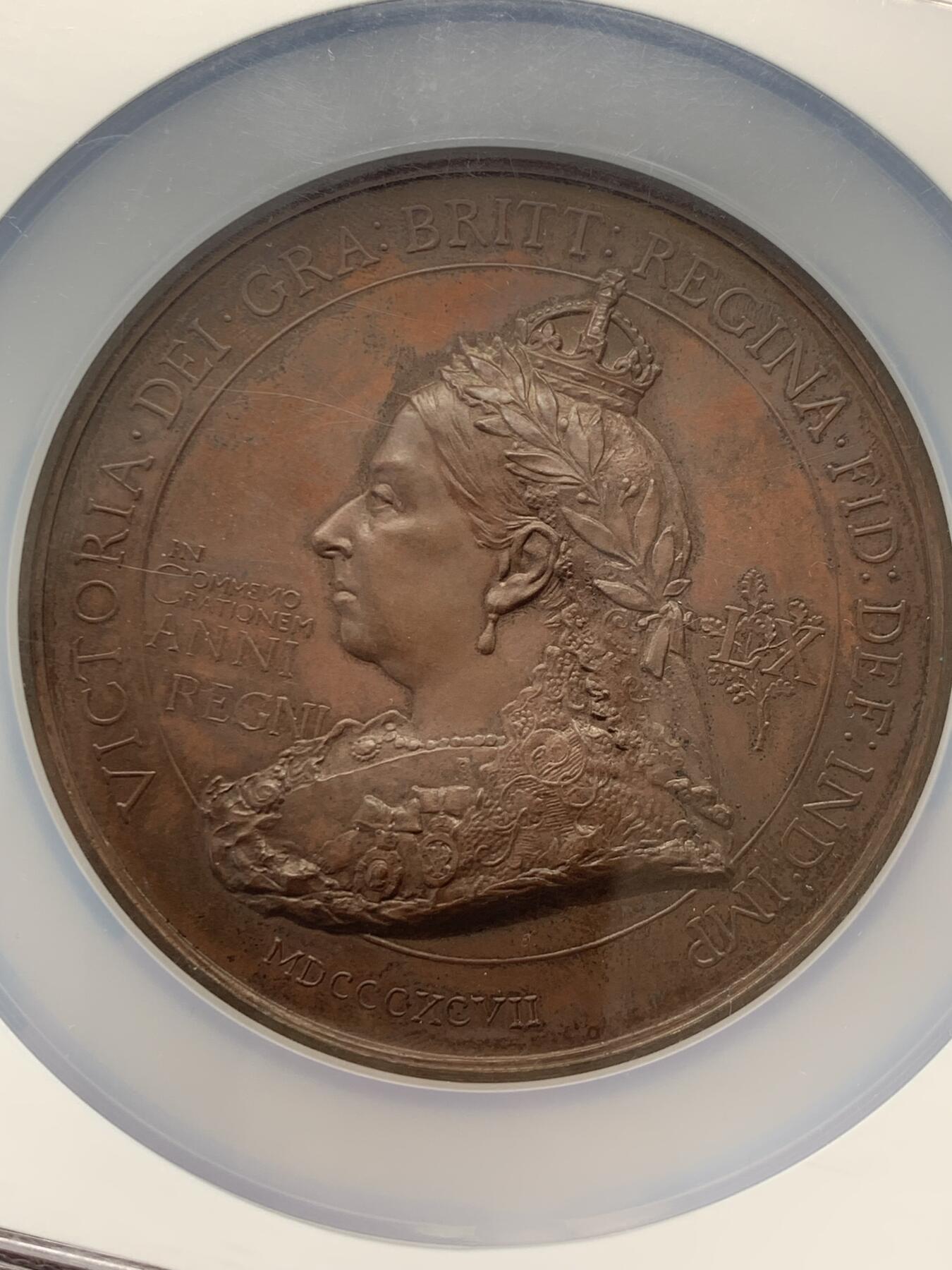 《竞宝斋》立夏专场特拍 （第2-1场）全场顺丰包邮 265场 NGC MS61BN 英国1897维多利亚钻石周年纪念铜章 大盒加厚 76MM 背后是双手合呈十字形，写着爱 和平 和 联合 55个盾牌上是英国领土以及殖民地名称 彰显日不落帝国的辉煌 也是英国帝国全球扩张的历史见证