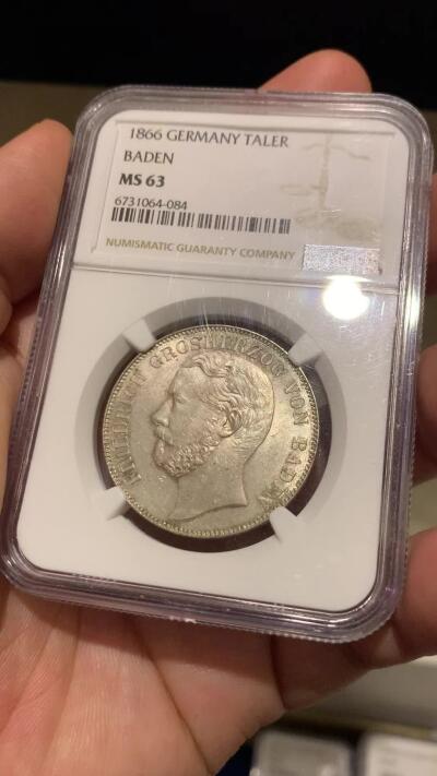 《竞宝斋》立夏专场特拍 （第2-1场）全场顺丰包邮 265场 NGC MS63 德国1866年巴登-杜拉赫公国1泰勒 该品种流通充分好品难寻 背面为经典的双狮鹫徽章 这枚全深打 整体细节和光度都很好 欧洲纸袋老包浆