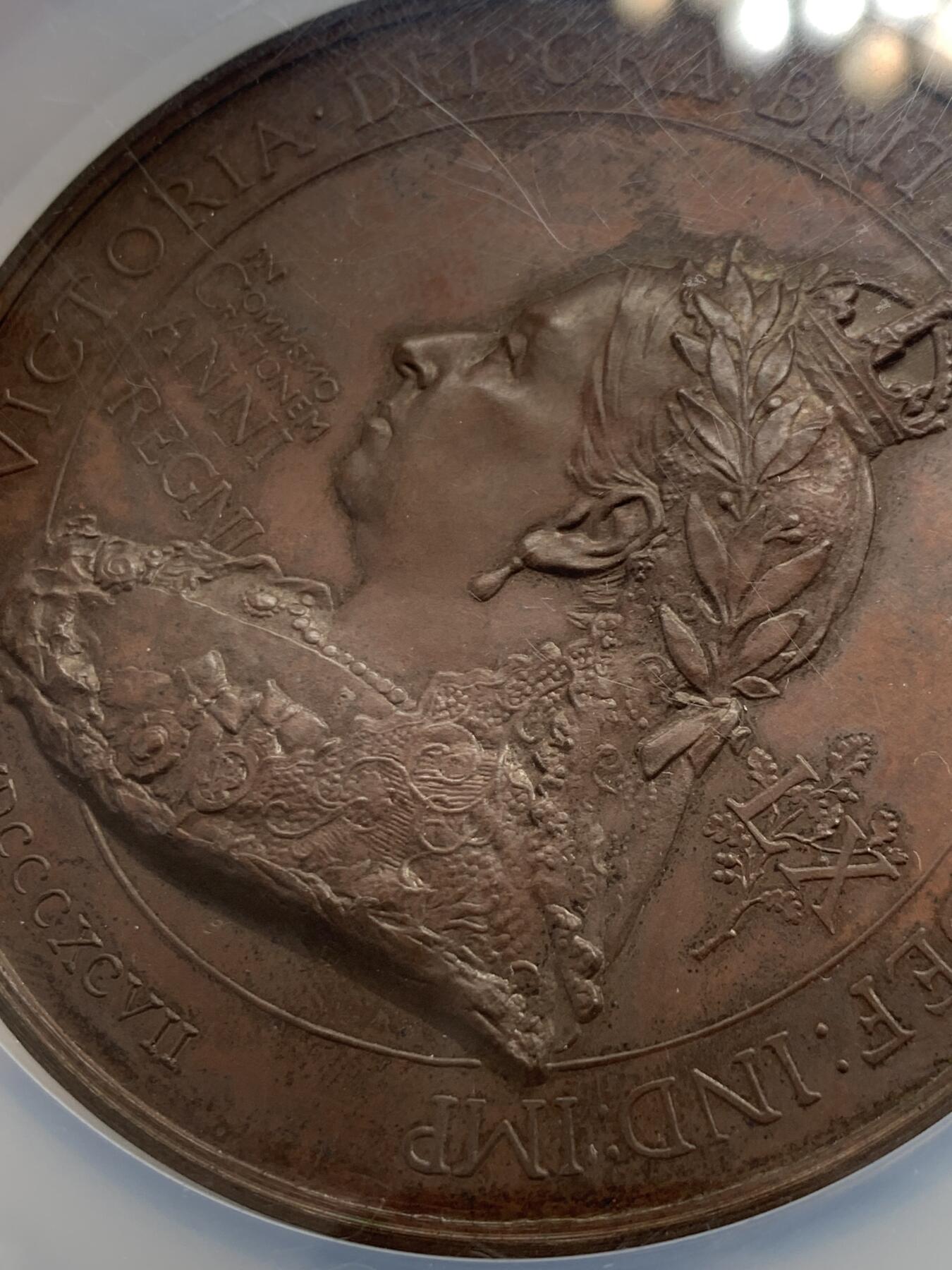 《竞宝斋》立夏专场特拍 （第2-1场）全场顺丰包邮 265场 NGC MS61BN 英国1897维多利亚钻石周年纪念铜章 大盒加厚 76MM 背后是双手合呈十字形，写着爱 和平 和 联合 55个盾牌上是英国领土以及殖民地名称 彰显日不落帝国的辉煌 也是英国帝国全球扩张的历史见证