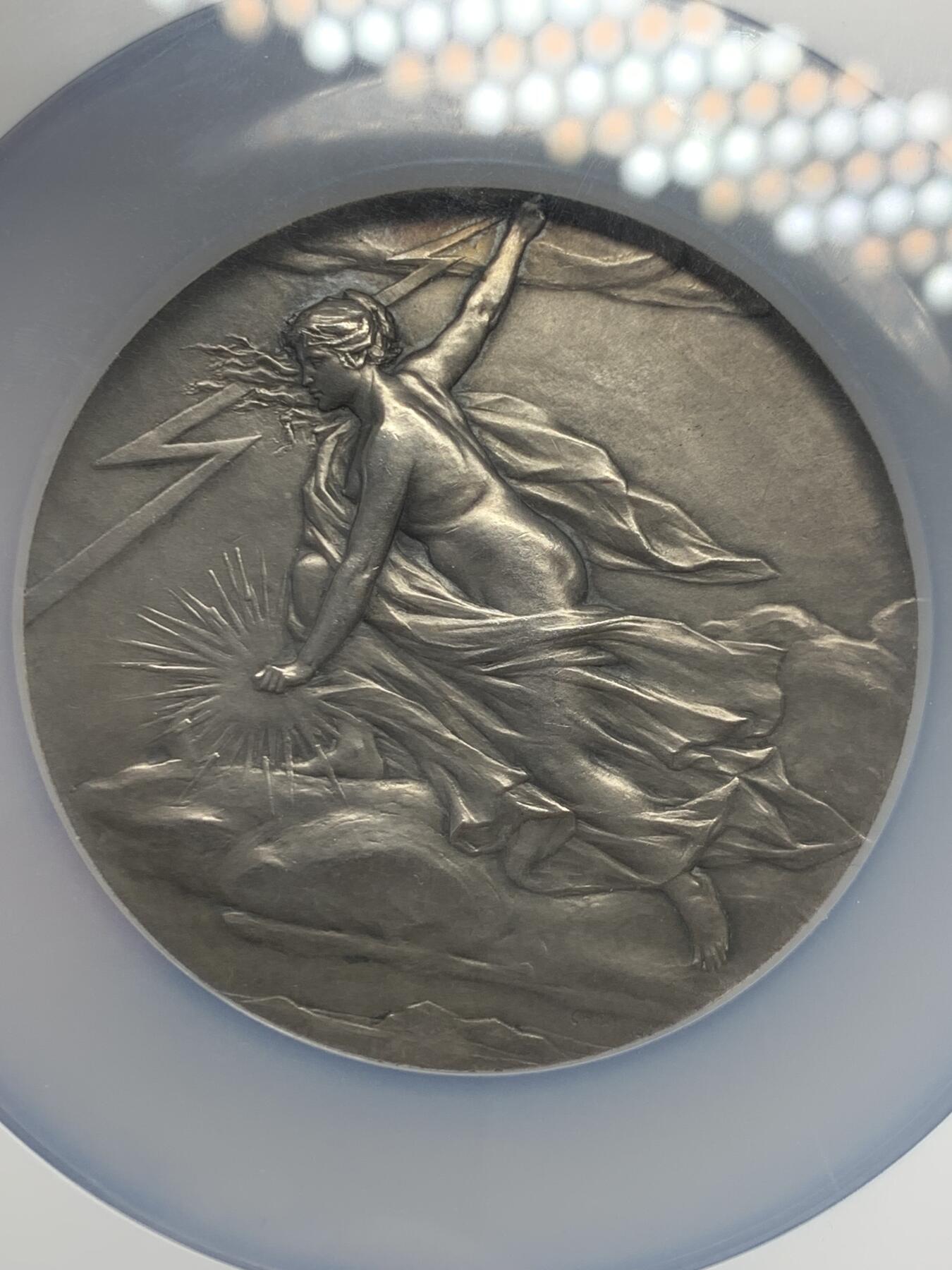 《竞宝斋》立夏专场特拍 （第2-1场）全场顺丰包邮 265场 NGC MS63 法国电力女神大银章，和法兰西银行百年、突尼斯开港都是68mm的精品大章，作者皮列是骑马鹰洋的雕刻师，法章名家。正面的裸身女神丰腴立体，背面是景观，一章两面都是精品。这个品种63高分罕见，章牌爱好者必冲。