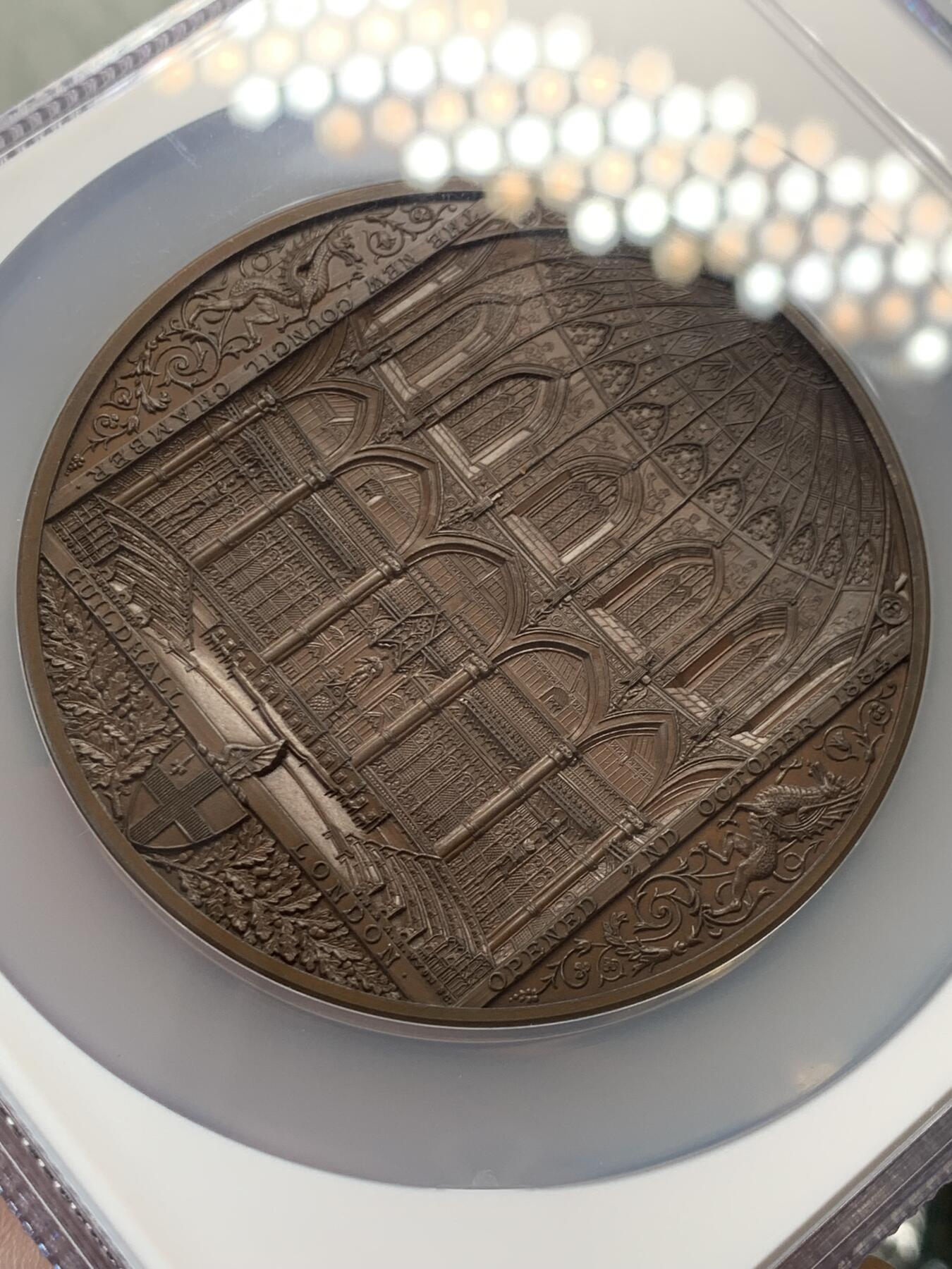 《竞宝斋》立夏专场特拍 （第2-1场）全场顺丰包邮 265场 NGC MS64BN 1884年英国伦敦金融城系列 建筑三杰之一 大不列颠市政厅铜牌新议会厅开幕 伦敦造币厂 作者JS & AB Wyon 直径77毫米 正面是伦迪尼亚 商业和治安法官出席 向她的议会发表讲话 背面是市政厅内景 此章是任何大教堂和建筑相关奖牌的高级收藏者的必备品