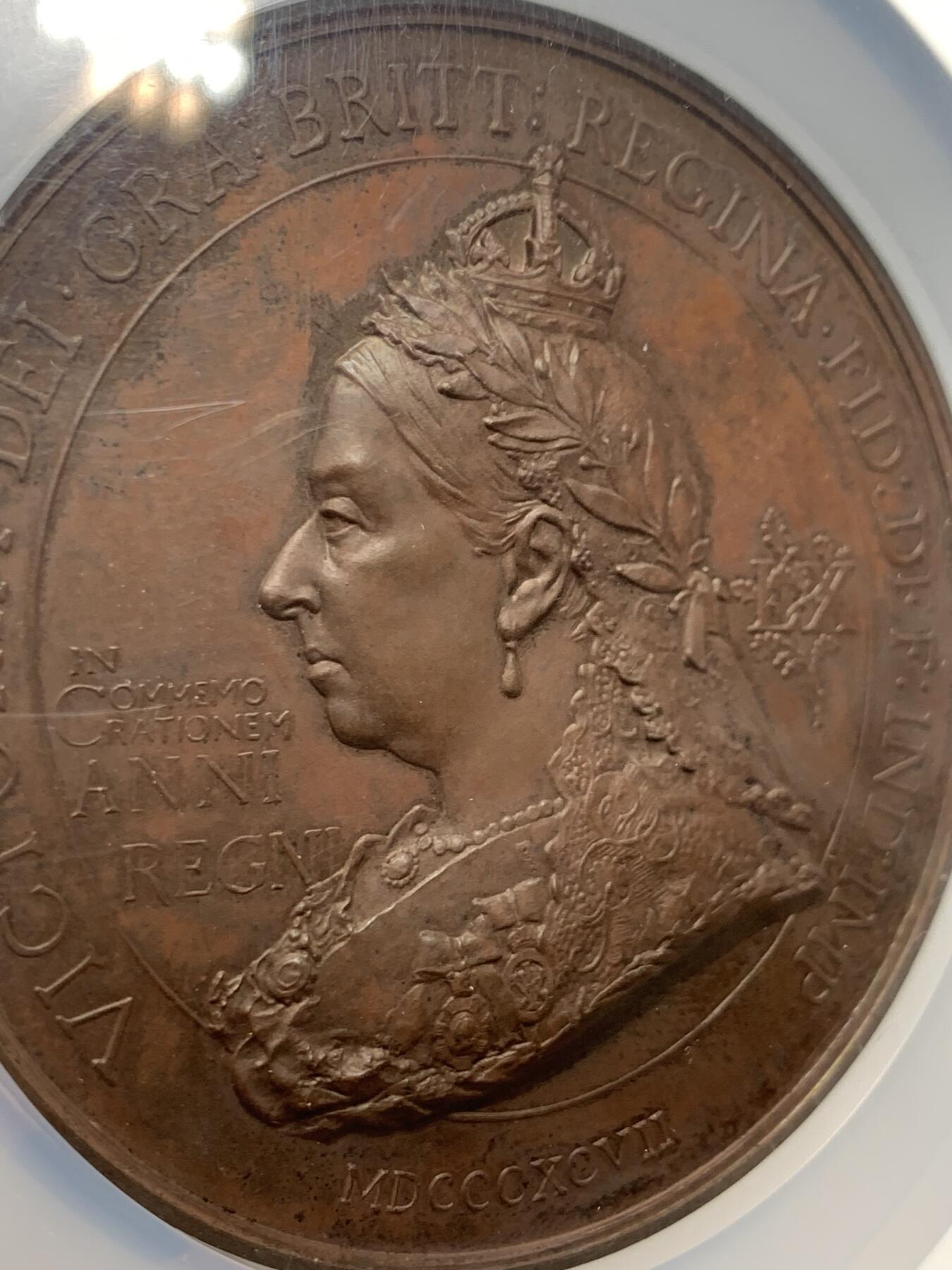 《竞宝斋》立夏专场特拍 （第2-1场）全场顺丰包邮 265场 NGC MS61BN 英国1897维多利亚钻石周年纪念铜章 大盒加厚 76MM 背后是双手合呈十字形，写着爱 和平 和 联合 55个盾牌上是英国领土以及殖民地名称 彰显日不落帝国的辉煌 也是英国帝国全球扩张的历史见证