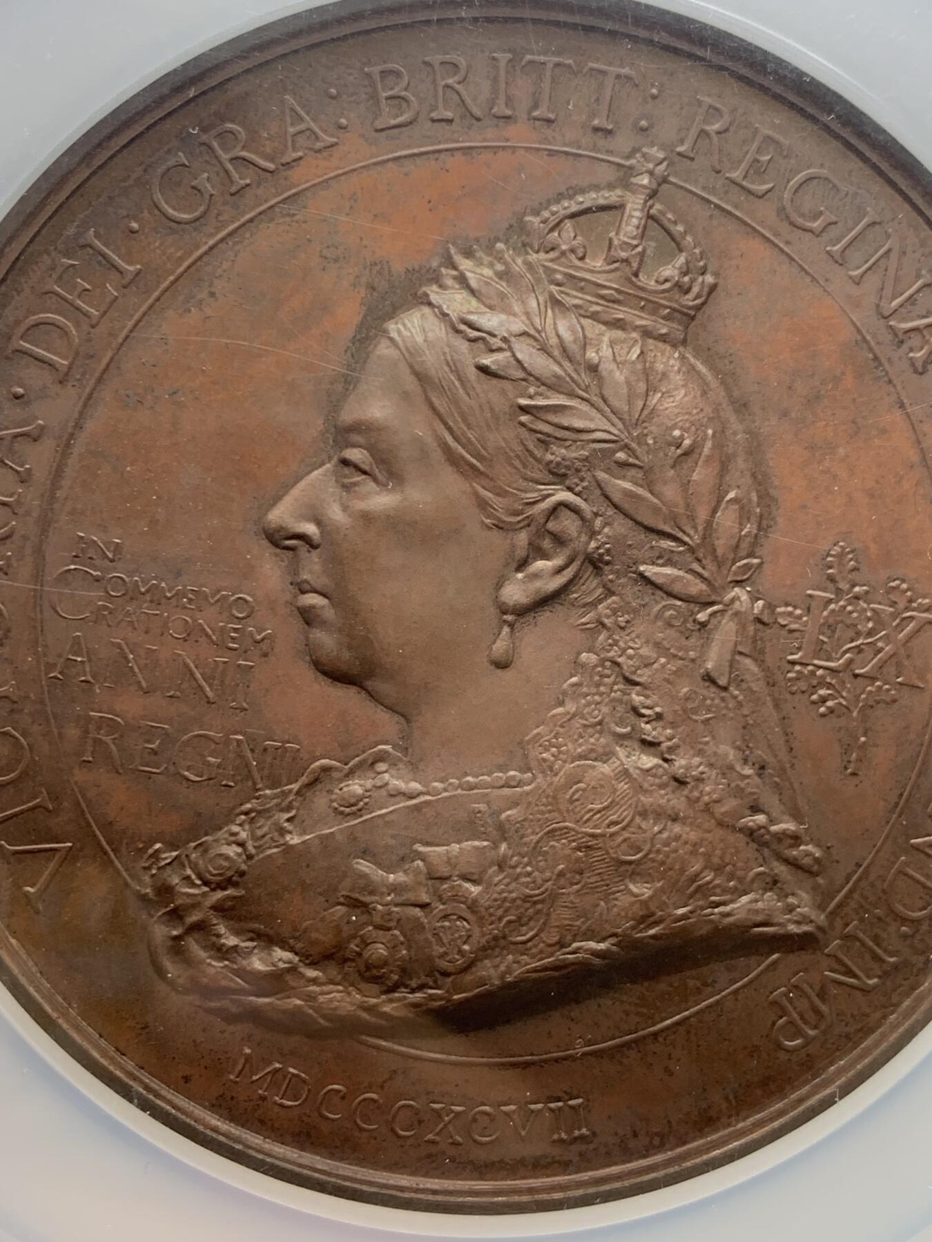 《竞宝斋》立夏专场特拍 （第2-1场）全场顺丰包邮 265场 NGC MS61BN 英国1897维多利亚钻石周年纪念铜章 大盒加厚 76MM 背后是双手合呈十字形，写着爱 和平 和 联合 55个盾牌上是英国领土以及殖民地名称 彰显日不落帝国的辉煌 也是英国帝国全球扩张的历史见证