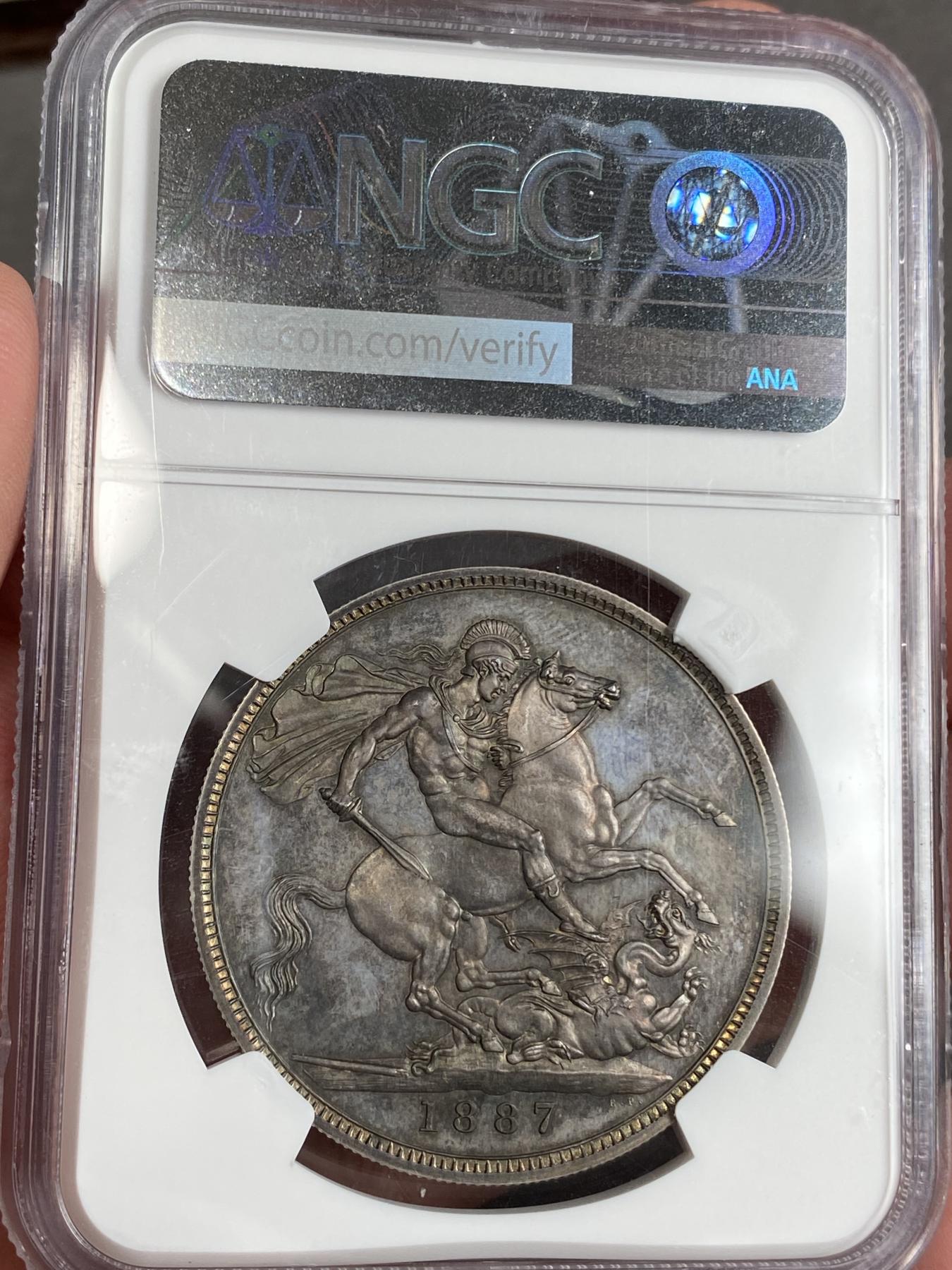 万国钱币拍卖第025期（槐月至·百币艳） NGC PF64 1887英国维多利亚高冠马剑精制克朗 发行量1084枚，在补涨一轮后依然是价格最为亲民的英国19世纪精制克朗，与爱七Matte和乔五精制木马相比依旧保留了古典时代的韵味，而精制工艺也达到了巅峰水准。英国的潮湿气候造就此枚马剑的双面欧陆五彩，在深度镜面的底板上反射出了日不落帝国最后的余晖。