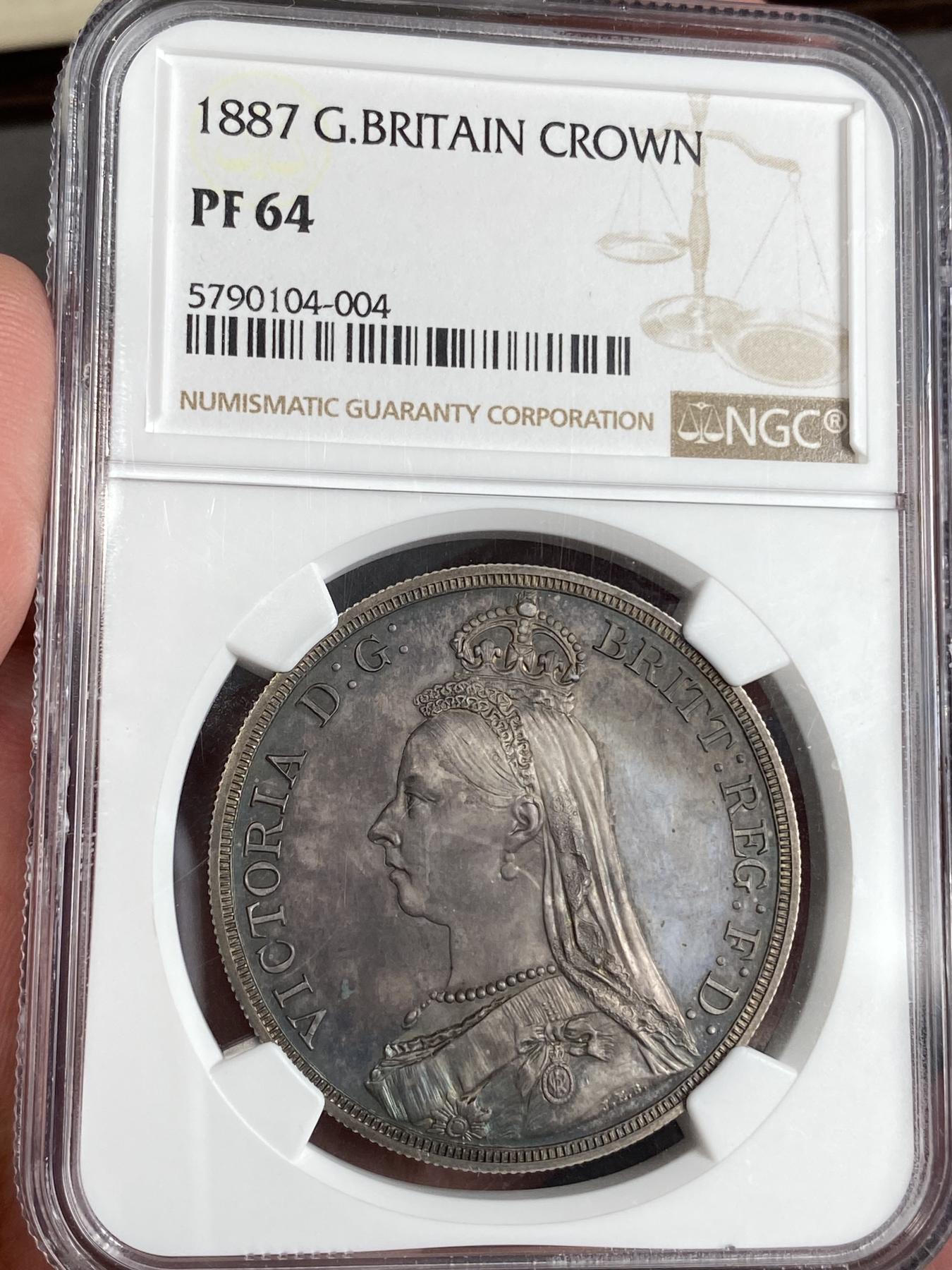 万国钱币拍卖第025期（槐月至·百币艳） NGC PF64 1887英国维多利亚高冠马剑精制克朗 发行量1084枚，在补涨一轮后依然是价格最为亲民的英国19世纪精制克朗，与爱七Matte和乔五精制木马相比依旧保留了古典时代的韵味，而精制工艺也达到了巅峰水准。英国的潮湿气候造就此枚马剑的双面欧陆五彩，在深度镜面的底板上反射出了日不落帝国最后的余晖。