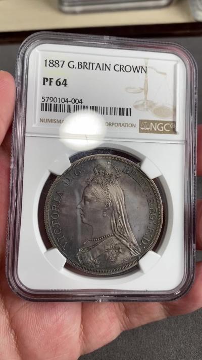 万国钱币拍卖第025期（槐月至·百币艳） NGC PF64 1887英国维多利亚高冠马剑精制克朗 发行量1084枚，在补涨一轮后依然是价格最为亲民的英国19世纪精制克朗，与爱七Matte和乔五精制木马相比依旧保留了古典时代的韵味，而精制工艺也达到了巅峰水准。英国的潮湿气候造就此枚马剑的双面欧陆五彩，在深度镜面的底板上反射出了日不落帝国最后的余晖。