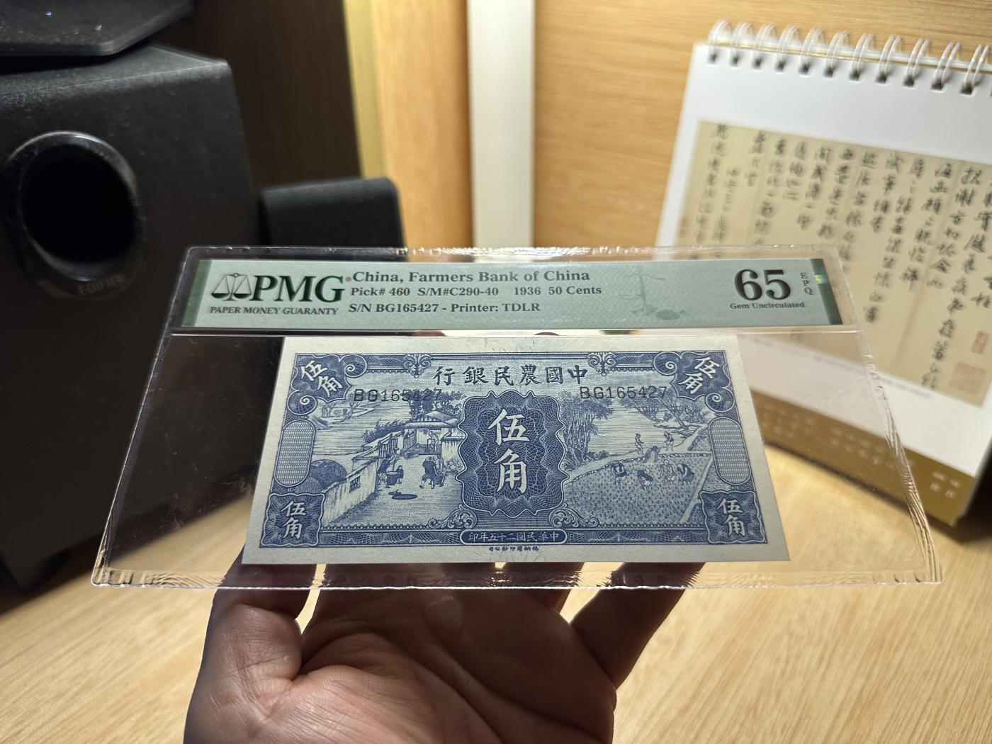 云山钞集 第211期 民国纸钞&一版人民币珍赏 民国25年中国农民银行德纳罗伍角，PMG评级封装季军得分。雍正耕织图系列中最美的一张，油墨堆砌效果远胜同系列其他品种，纸上之浮雕青花瓷，堪称民国纸币工艺巅峰之作。该品种真正原票绝品极为难得，所见获评PMG高分者，大多有裁边修饰，甚至洗水处理，本项为群主多年前自藏家手中求得，未经任何人为处理，无美容无修饰，硬评高分。本场重点拍品，敬请关注！